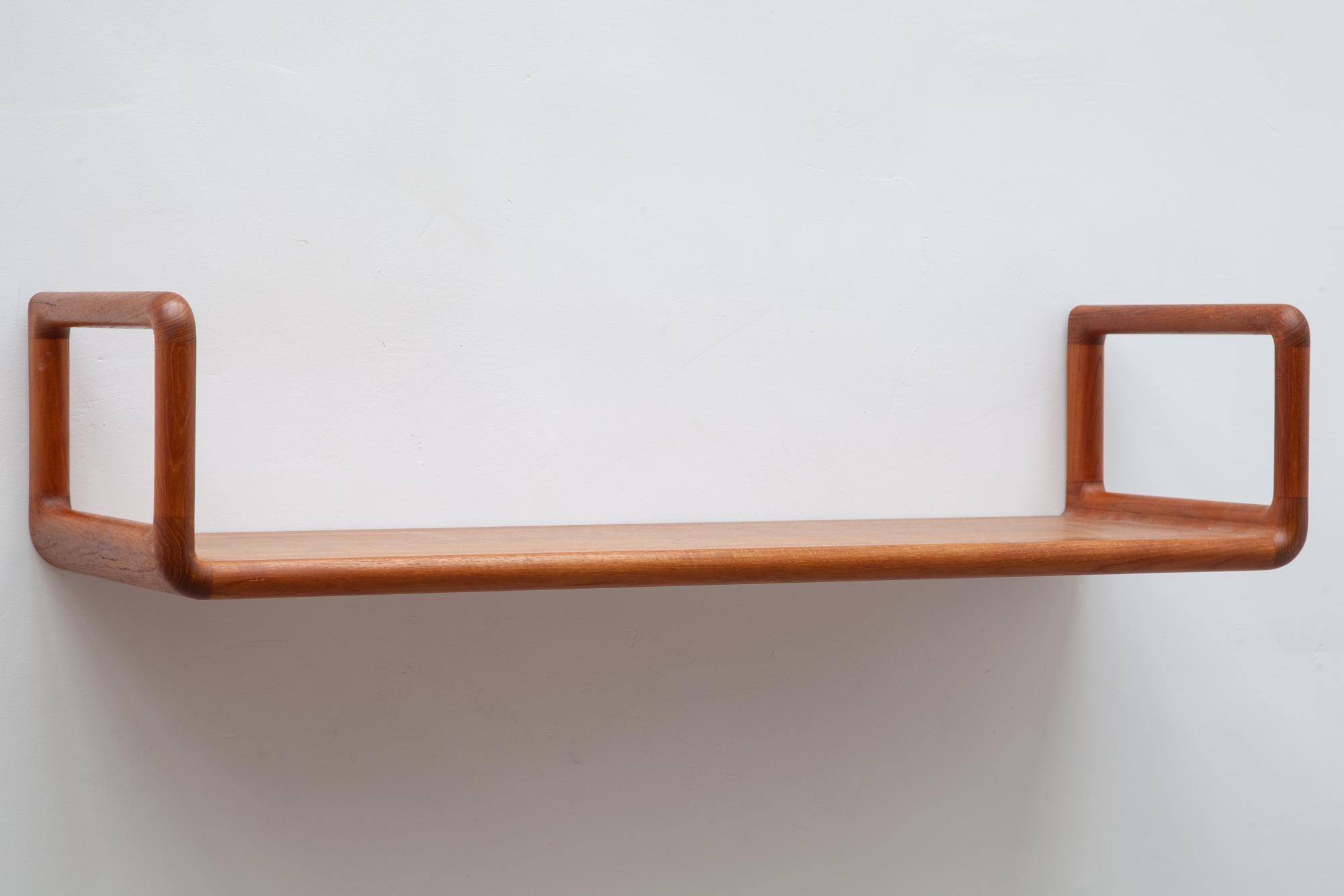 Danish teak wall shelves in classic midcentury design by Kai Kristiansen. Hanging style with soft rounded edges.
These teak shelves are a perfect example of a simple Danish design. Invisible hardware on the back creates a floating-on-the-wall