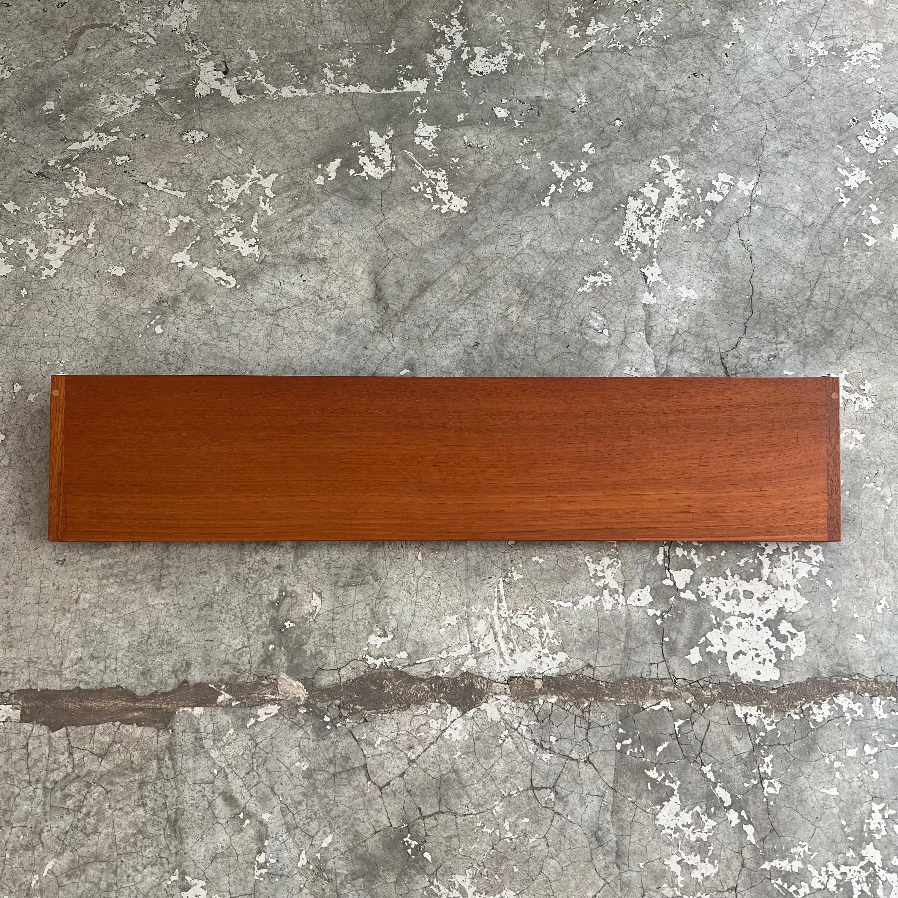 This shelf was designed by Kai Kristiansen for the Danish publisher Feldalles Møbler in the 1960s. This designer is a major figure in 20th century Scandinavian design. He is known for his modular shelving. The structure of these shelves is in teak,