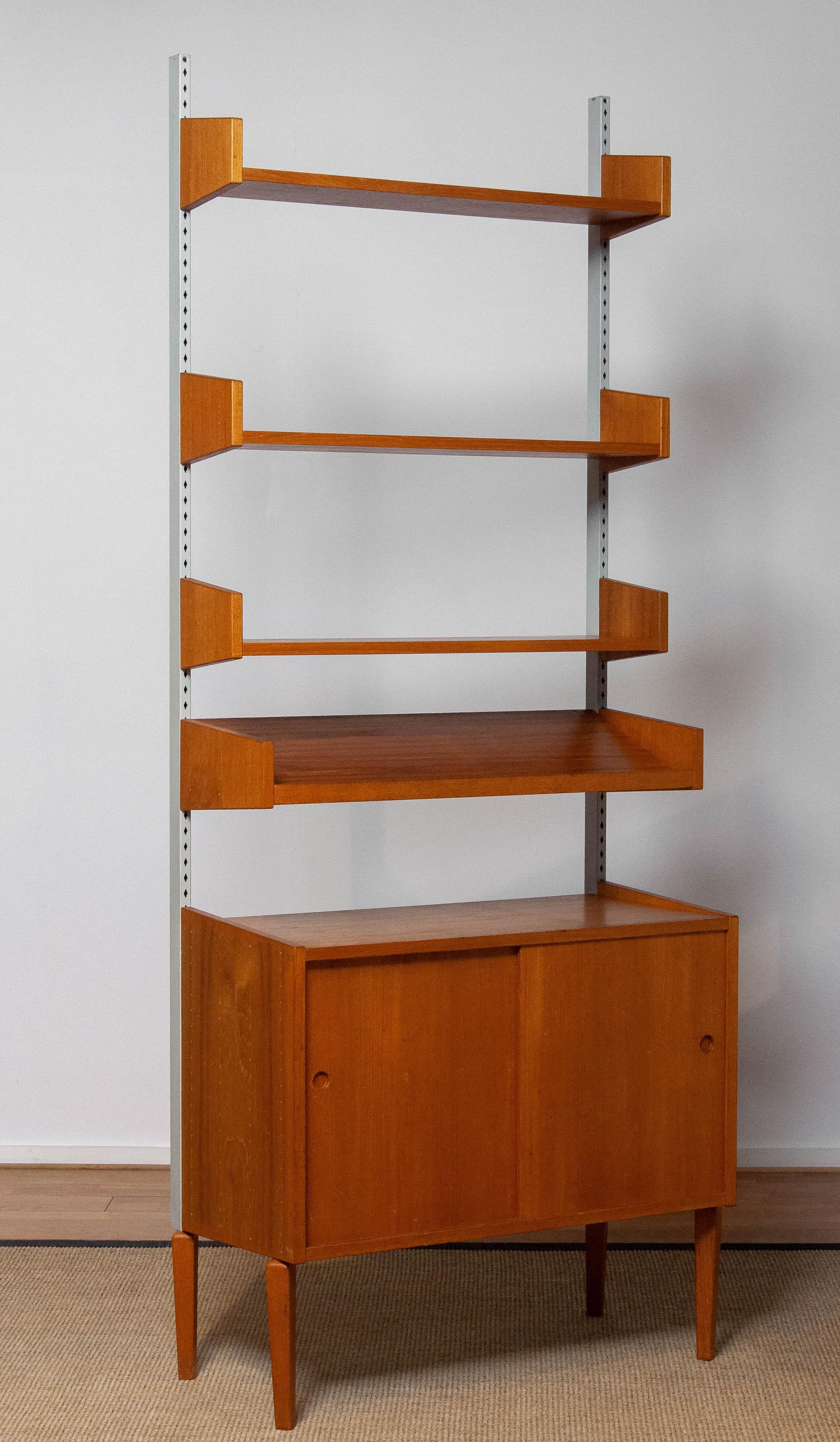 Beautiful and extremely rare modulair shelf system designed by Harald Lundqvist for Lizzy Element Möbel Sweden from the 1950's. The three shelfs are adjustable in hight as well as the presentation shelf. The cabinet has two sliding doors and also an