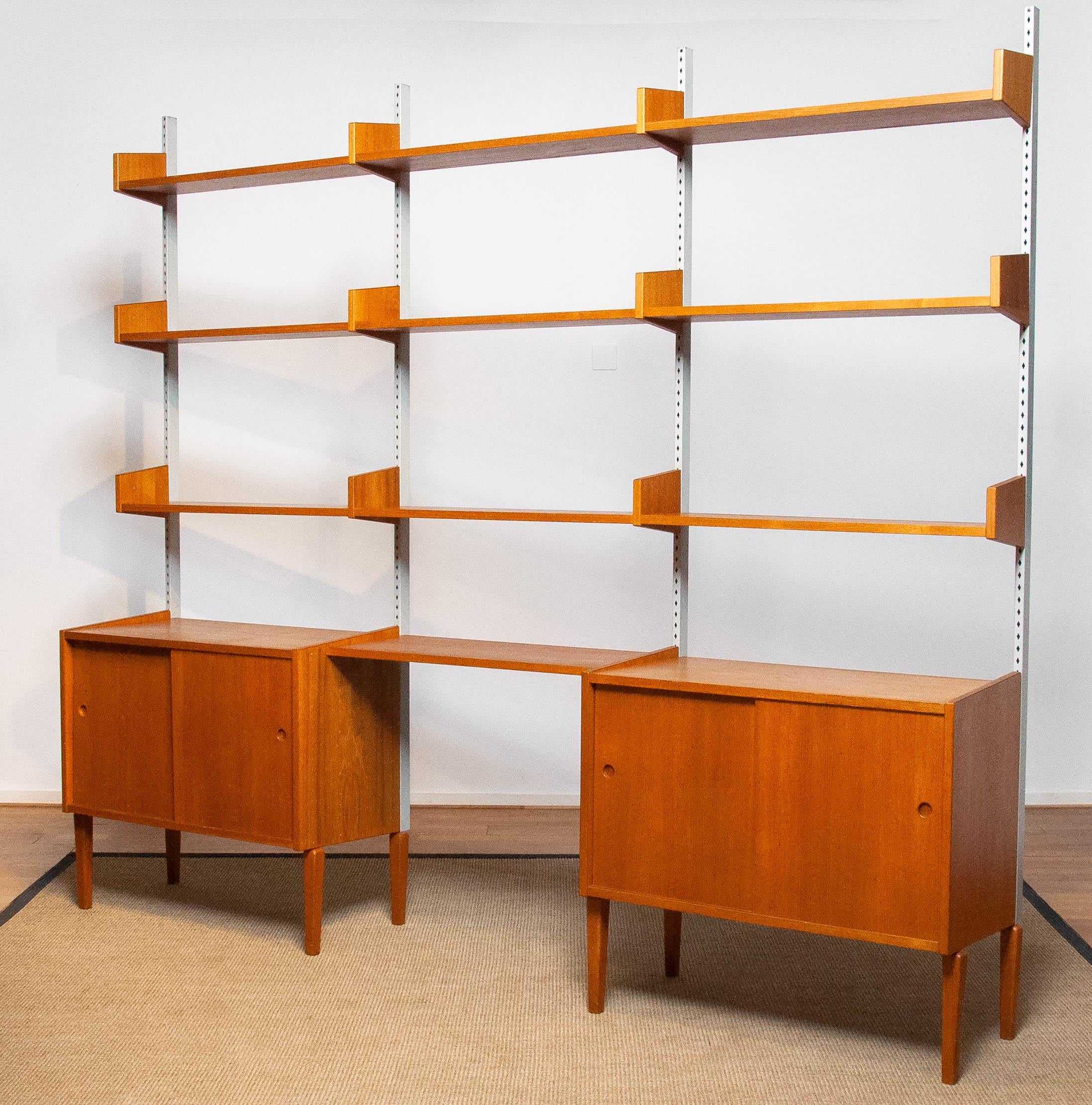 Beautiful and extremely rare modulair shelf system designed by Harald Lundqvist for Lizzy Element Möbel Sweden from the 1950's. The top-shelfs are adjustable in hight. The cabinets both have two sliding doors and also an adjustable shelf inside. The