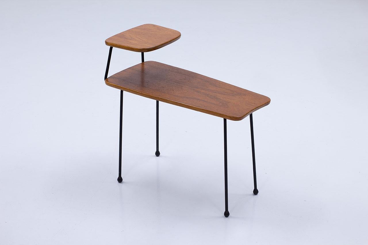 Elegante table d'appoint à la manière du travail de Greta Magnusson Grossman.
Fabriqué par Hugo Troeds à Bjärnum, en Suède, dans les années 1950.
Surfaces en teck et pieds en acier noir émaillé. 