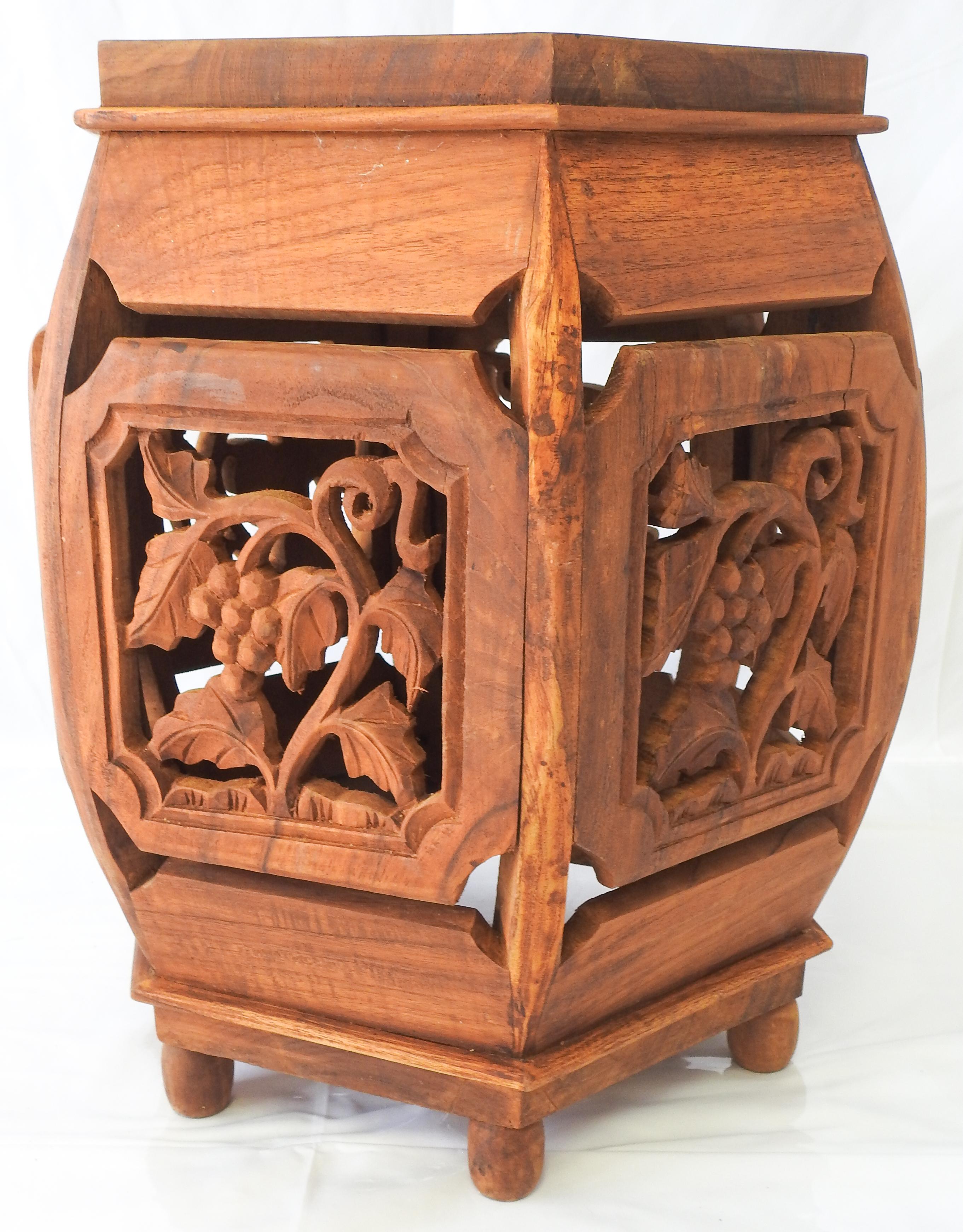 hand carved teak side table. Carved with panels of foliate and grape motif. The table sits on a ball foot and are in a hexagonal shape. All the trim is good shape.