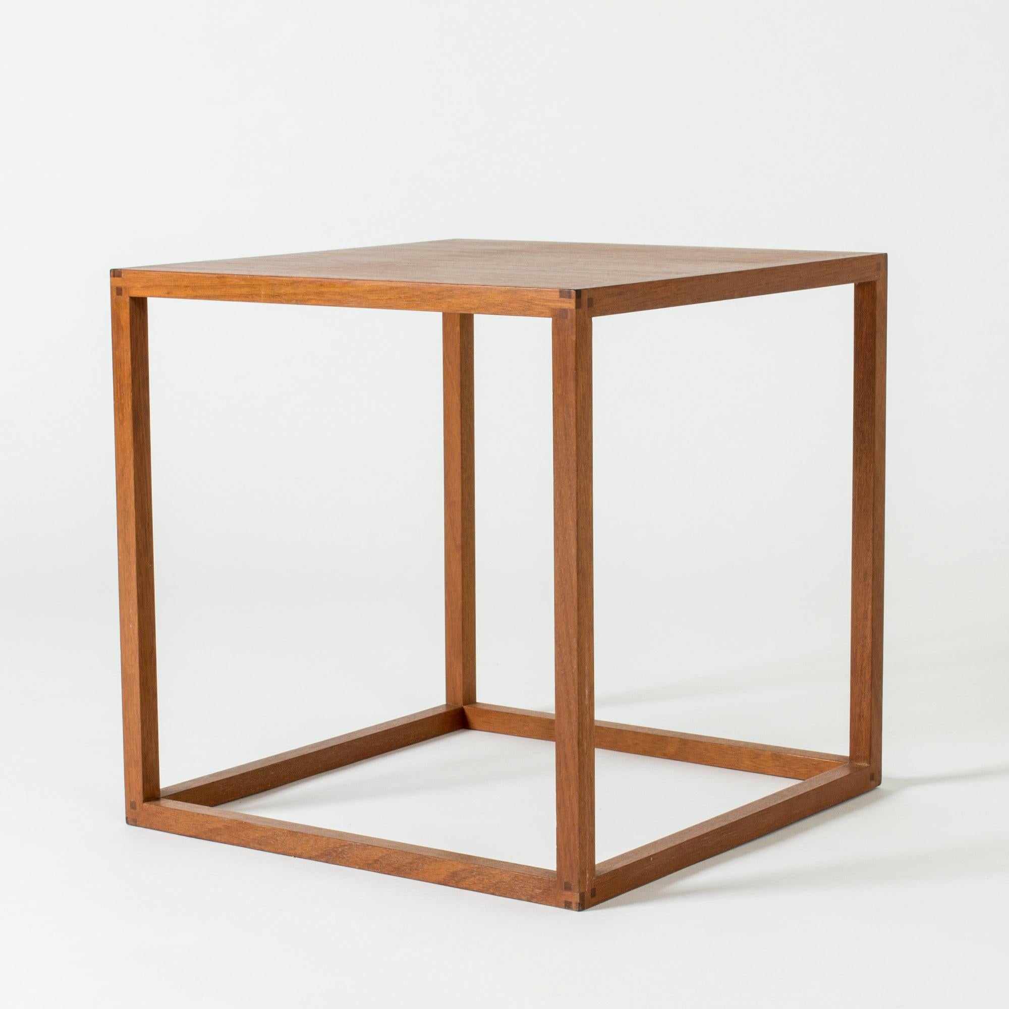 Cool teak side table from HI-gruppen, in a cubical design with an open silhouette. Elegant decorative details in the corners.