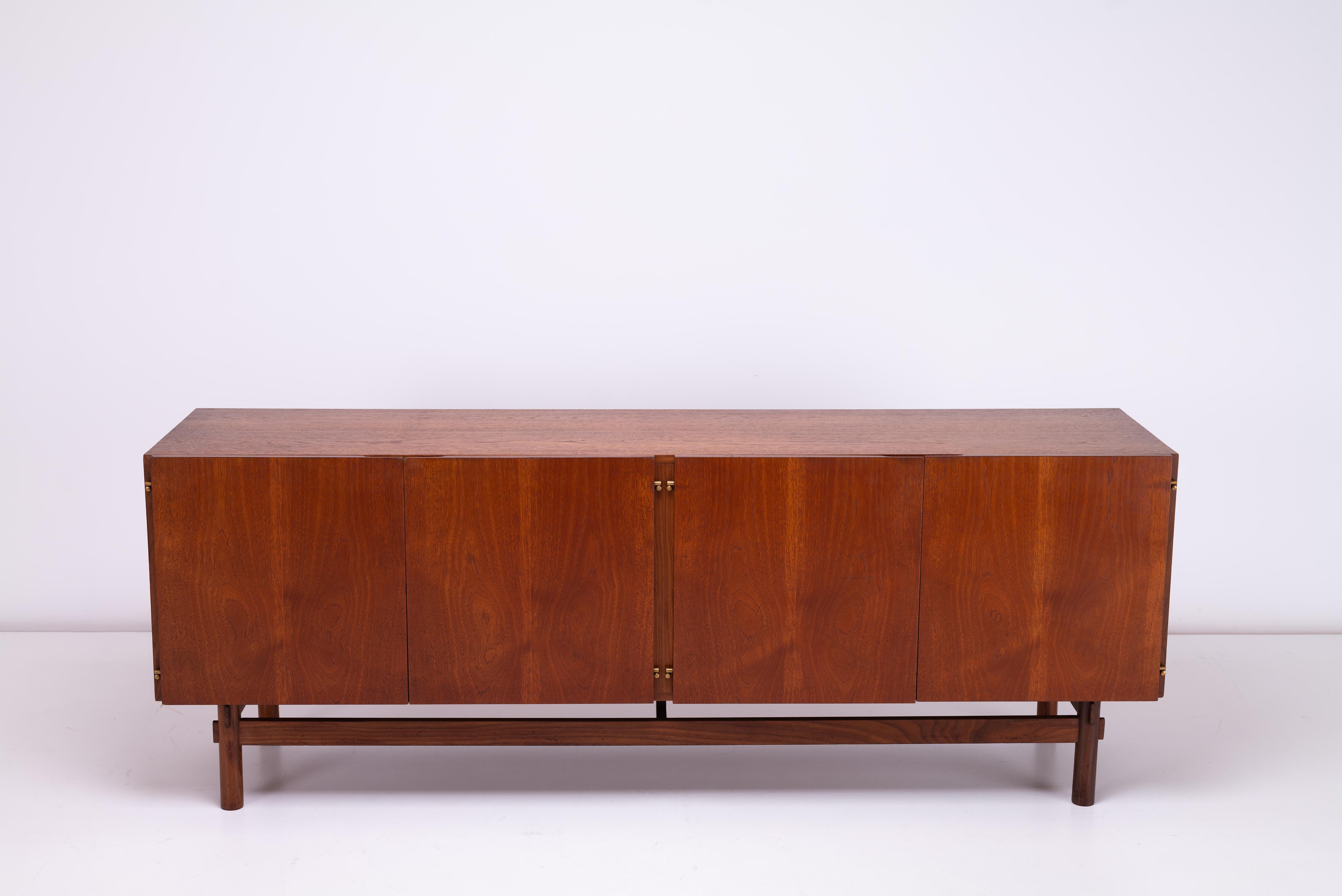 Ce superbe buffet en teck britannique des années 1970 allie sans effort un design classique du milieu du siècle à des éléments modernistes, ce qui en fait un ajout unique et fonctionnel à tout intérieur. Le buffet à quatre portes est doté de petites