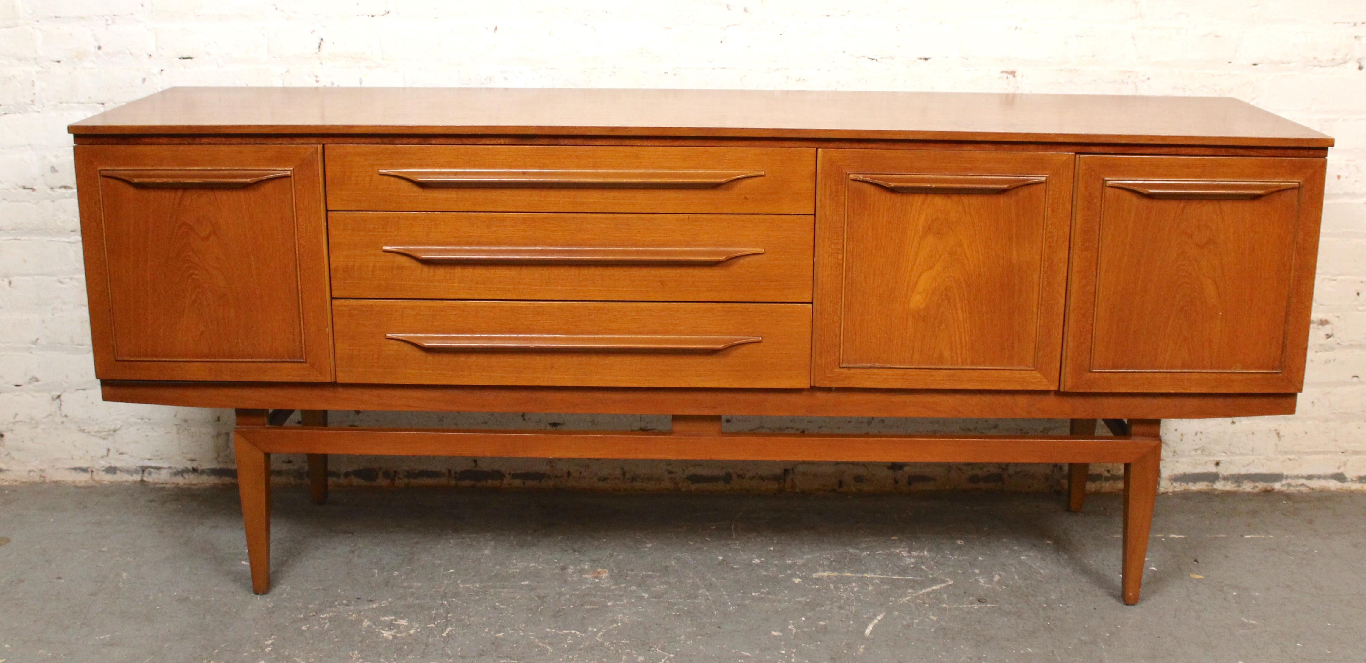 Buffet en bois de teck d'une longueur de deux mètres, fabriqué par Beautility Furniture au Royaume-Uni. Magnifique design de style danois avec des poignées en bois sculpté, un plateau flottant et des pieds fuselés. Deux espaces de rangement de part