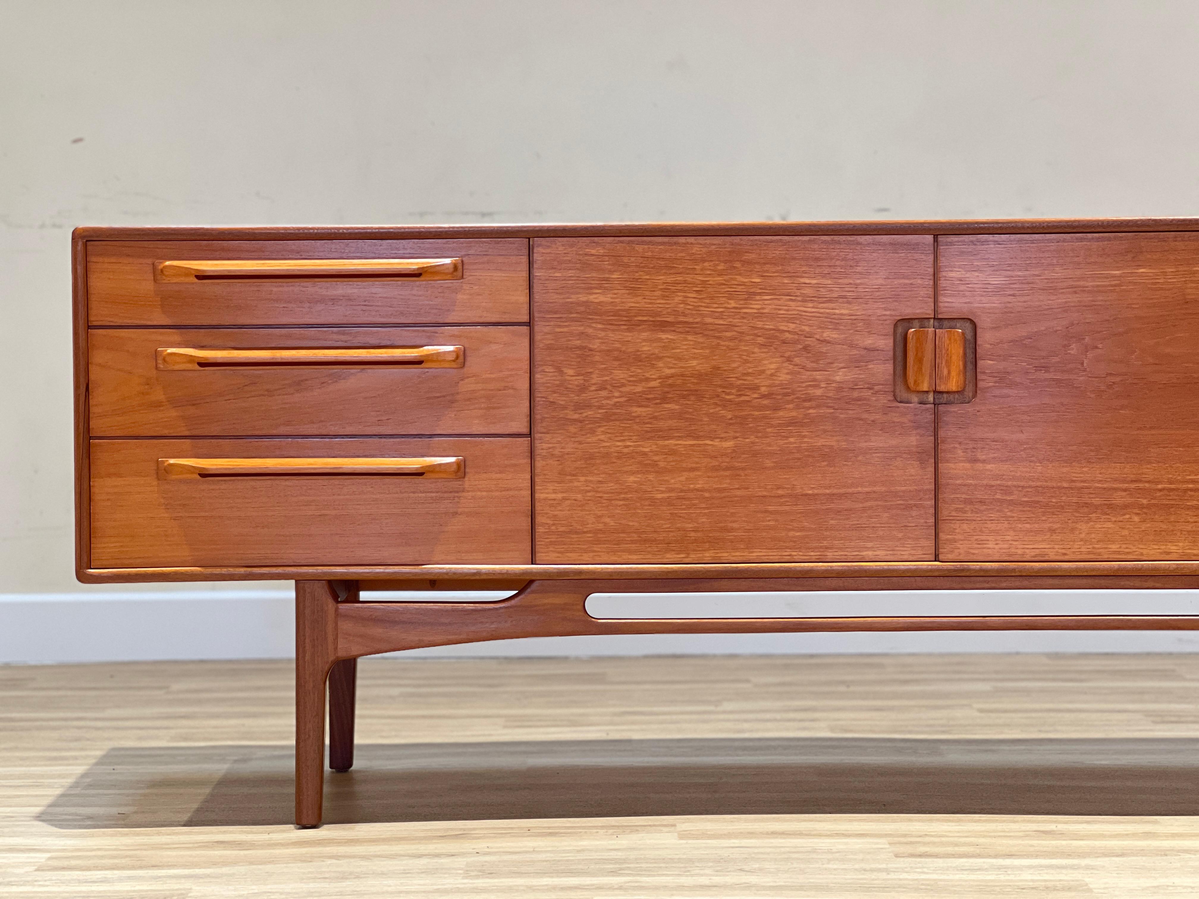 This exquisite teak sideboard was produced in the 1960s by Beithcraft, a renowned Scottish furniture manufacturer, known for their exceptional quality. The design of this piece was heavily influenced by the Danish furniture makers of that era.

The