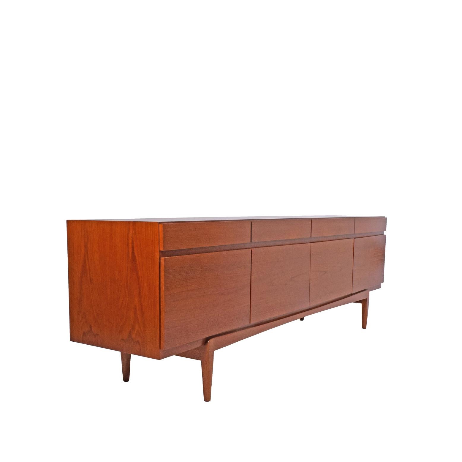 Free standing teak modern credenza four drawers and four doors one with expose finger join shallow pull out / pull-out drawers three other compartments with adjustable shelves. Danish quality label.