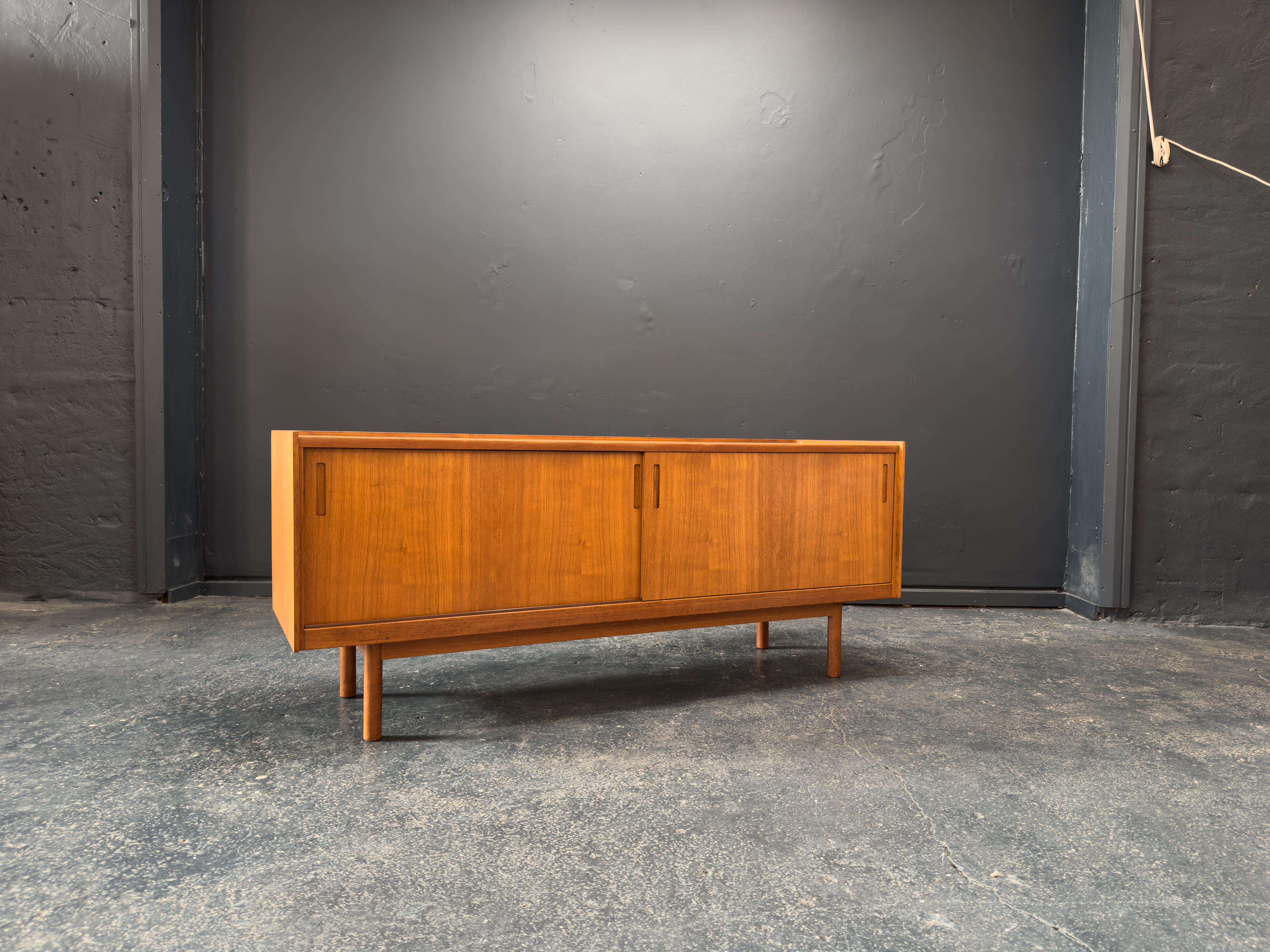 This elegant mid-century teak sideboard, designed by J. Clausen for Brande Møbelfabrik, is a beautiful expression of Danish modernism, characterised by its clean lines, thoughtful proportions, and functional craftsmanship.

Crafted from richly toned