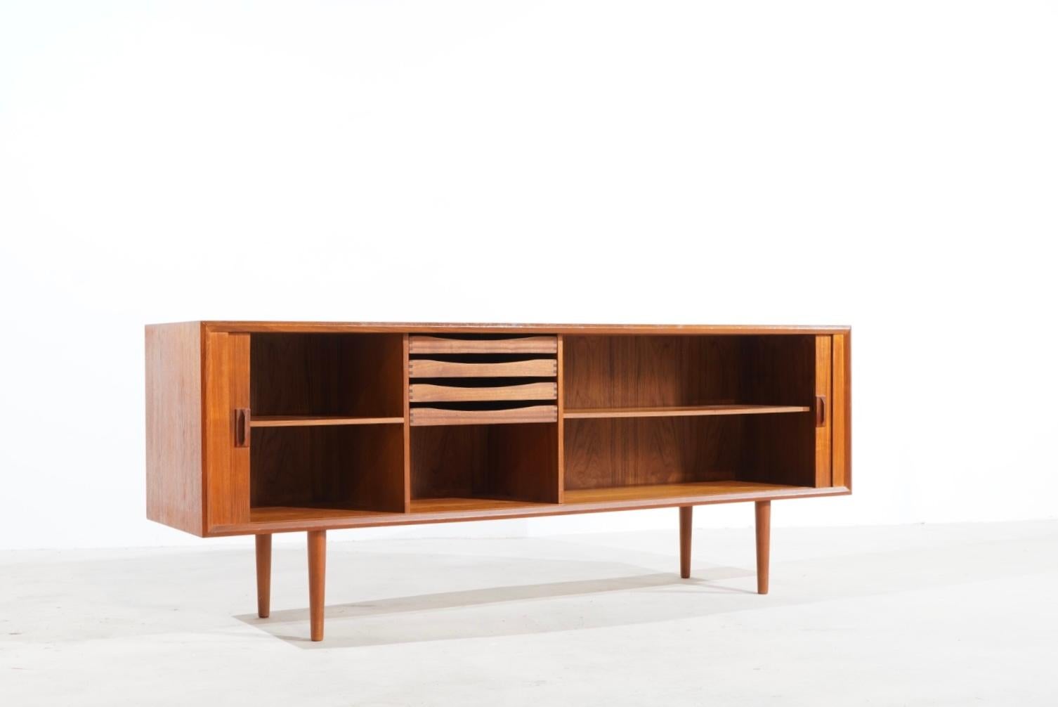 Sideboard designed by Svend Aage larsen Manufactured in Denmark by Faarup furniture factory in the 1960s. The teak sideboard with roller doors impresses with an outstandingly beautiful veneer pattern and clear, elegant design language. 