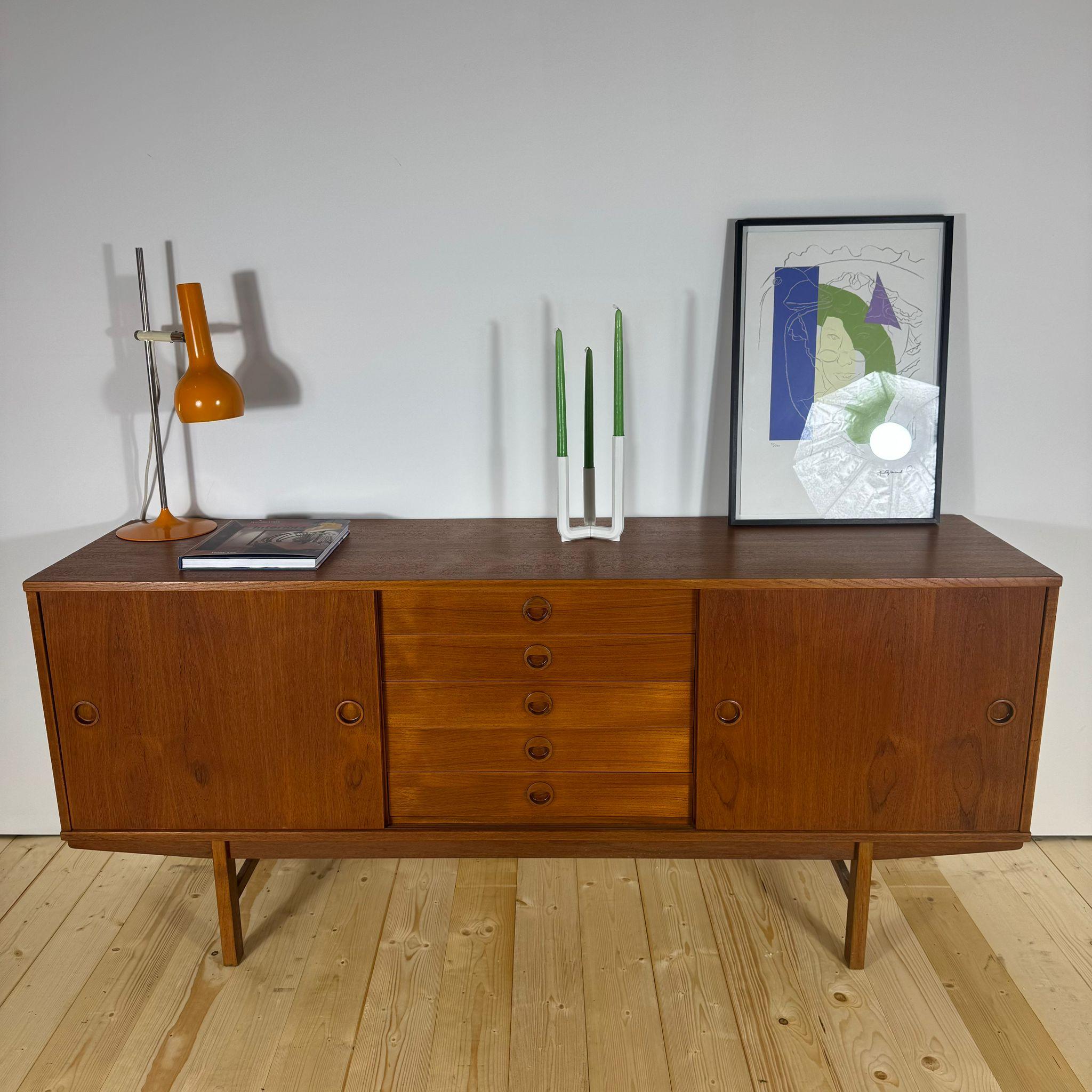 Straordinaria madia in teak disegnata da Yngve Ekstrom per DUX, Svezia, anni Cinquanta. Questo mobile sideboard presenta ante scorrevoli laterali con ripiani interni regolabili e cinque cassetti centrali. In ottime condizioni vintage, Invecchiato