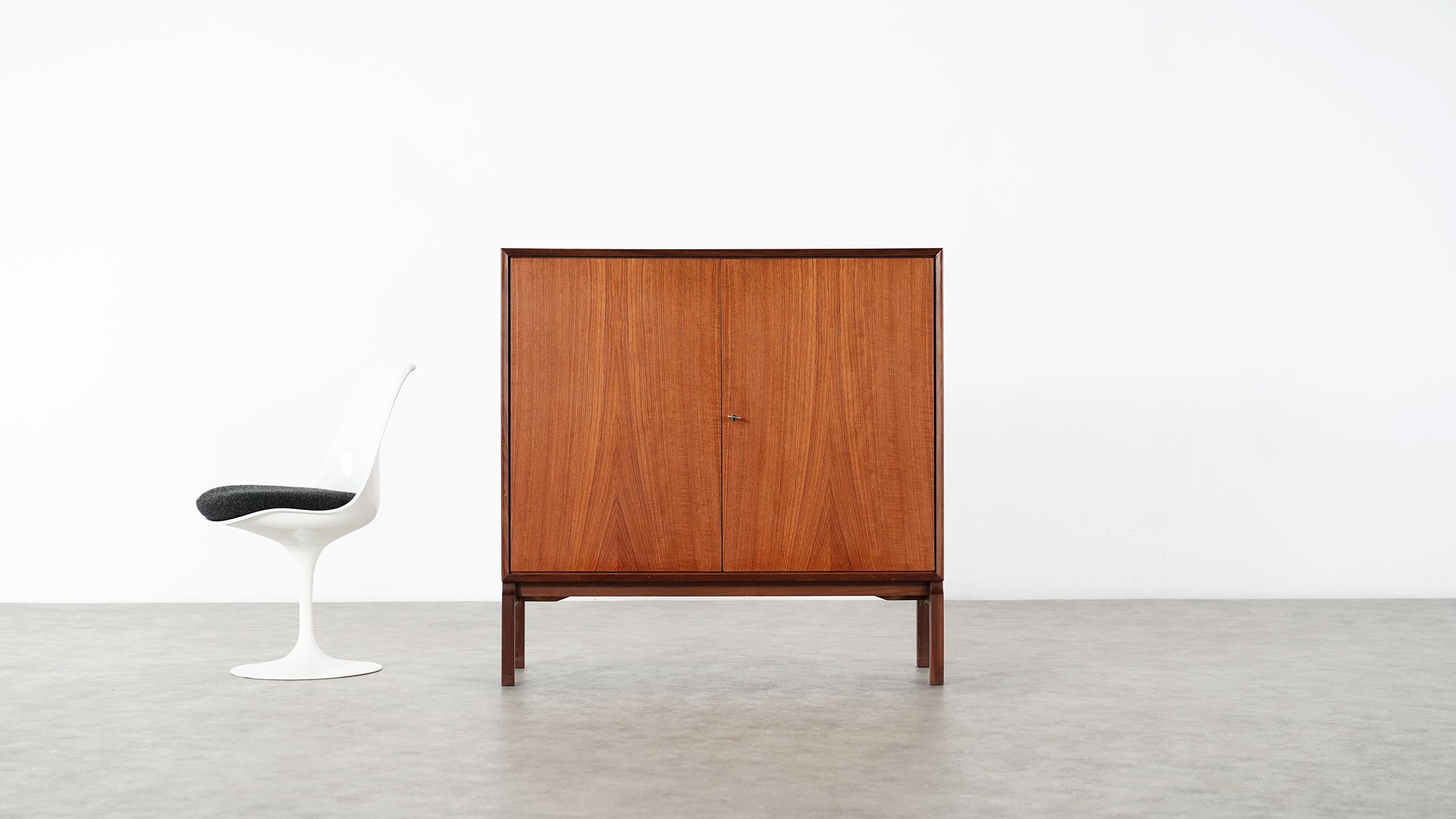 Very elegant and minimalistic teak Highboard from Denmark.

Measures: only 110cm wide, 109cm high and 40cm deep it is nevertheless spacious.
2 teakdoors closing with their original key are hiding 2 Arne Vodder like shaped drawers.

Really nice