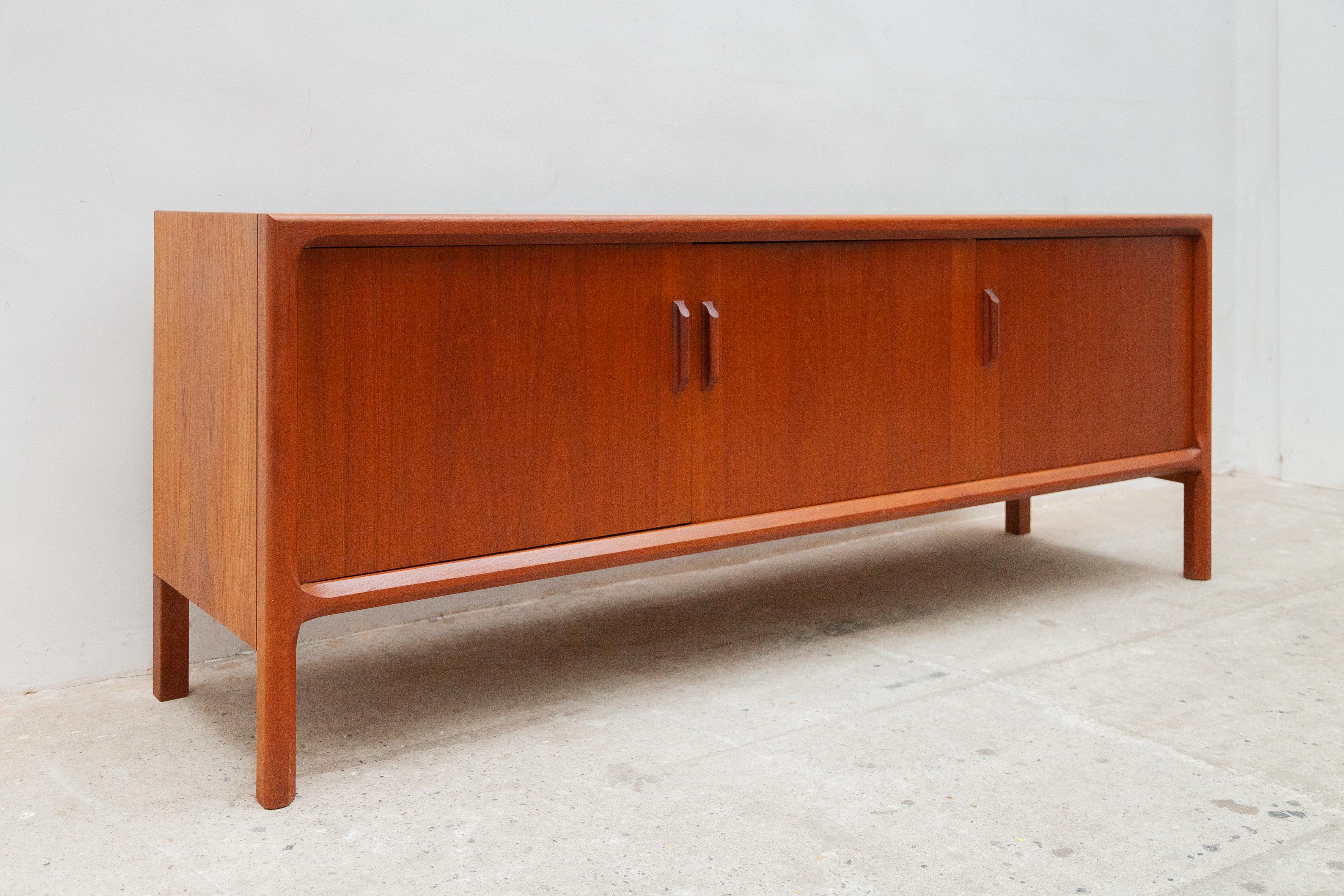 Vintage Danish three doors sideboard was designed by Dyrlund furniture makers in the 1960s. Dyrlund is well known for its high-quality Danish furniture and this piece perfectly reflects that. The interior has 2 drawers and 3 adjustable shelves