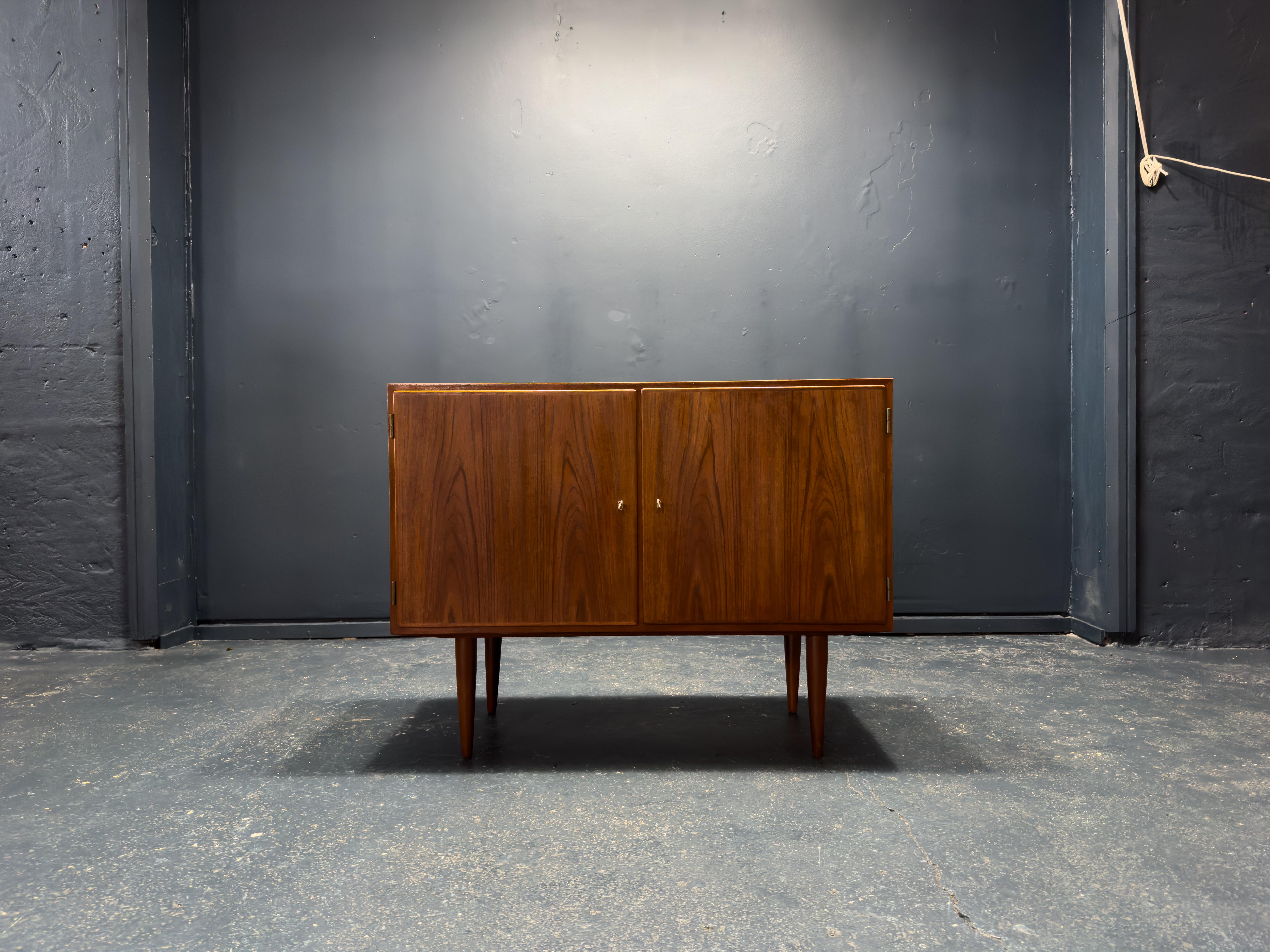 This teak sideboard is a stunning example of mid-century craftsmanship, combining clean lines, refined simplicity, and functional storage. Crafted from richly grained teak, the wood’s warm, honeyed tones enhance its timeless appeal, while the subtle