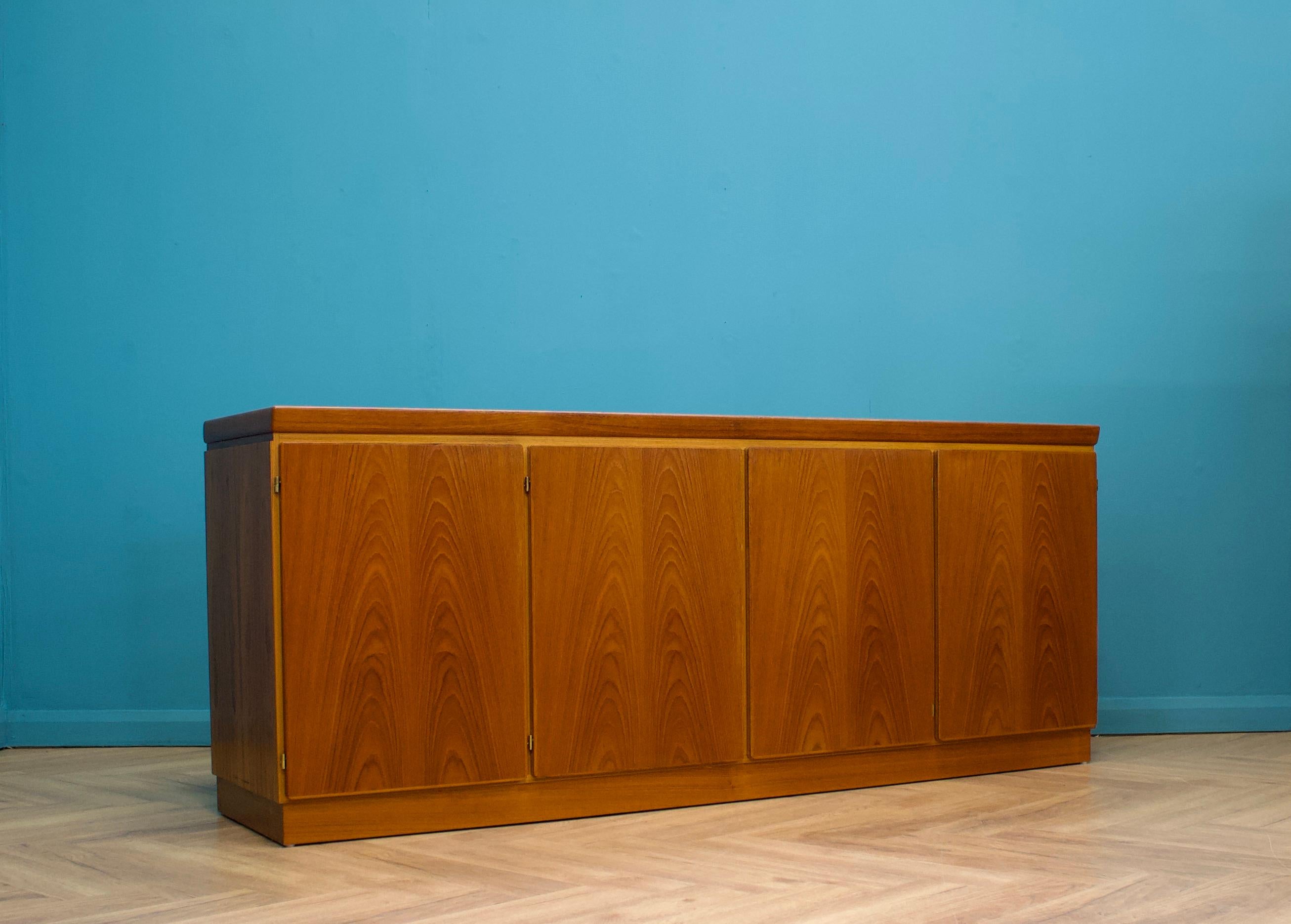 A mid century Danish teak sideboard from Skovby, circa 1970s

A sleek minimalist design - featuring four cupboard doors, each with shelving or drawers