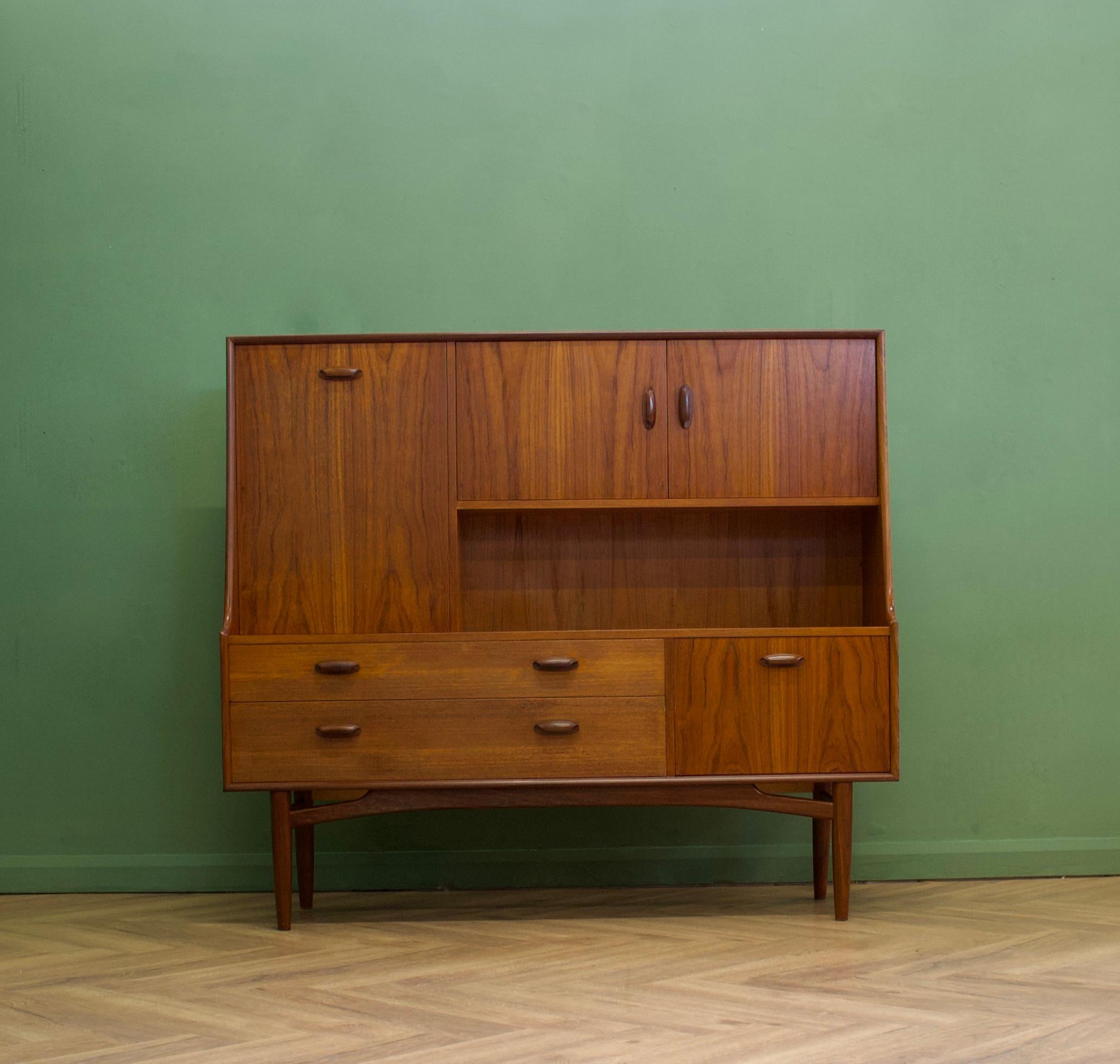 A compact size teak drinks cabinet or highboard from G Plan - Circa 1960s

It features a two cupboards, a pull down drinks compartment, two drawers and removable shelves

Each handle is solid teak