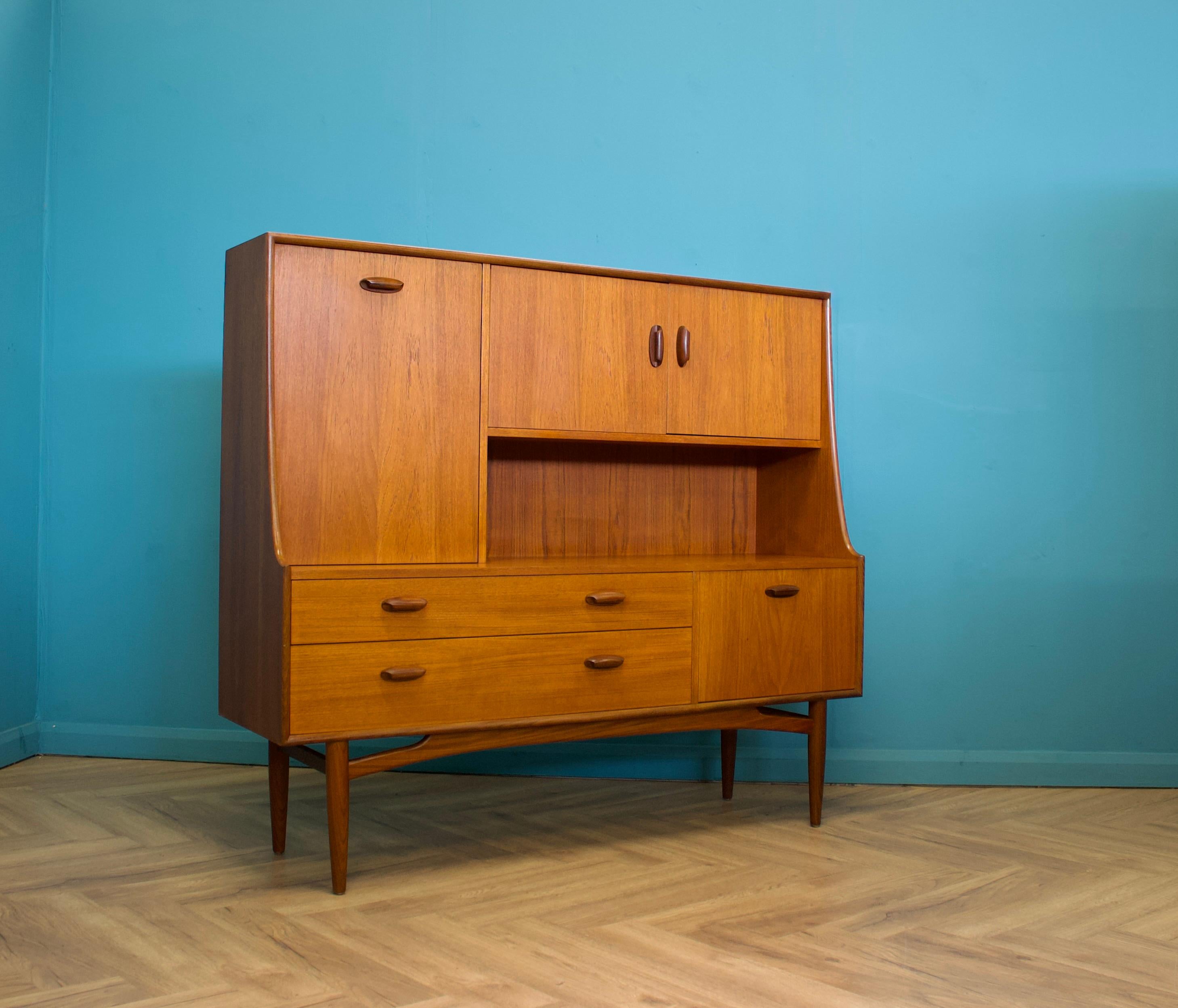 Meuble à boissons ou buffet en teck de taille compacte de G-Plan - Circa 1960s

Il comprend deux armoires, un compartiment à boissons escamotable, deux tiroirs et des étagères amovibles.


