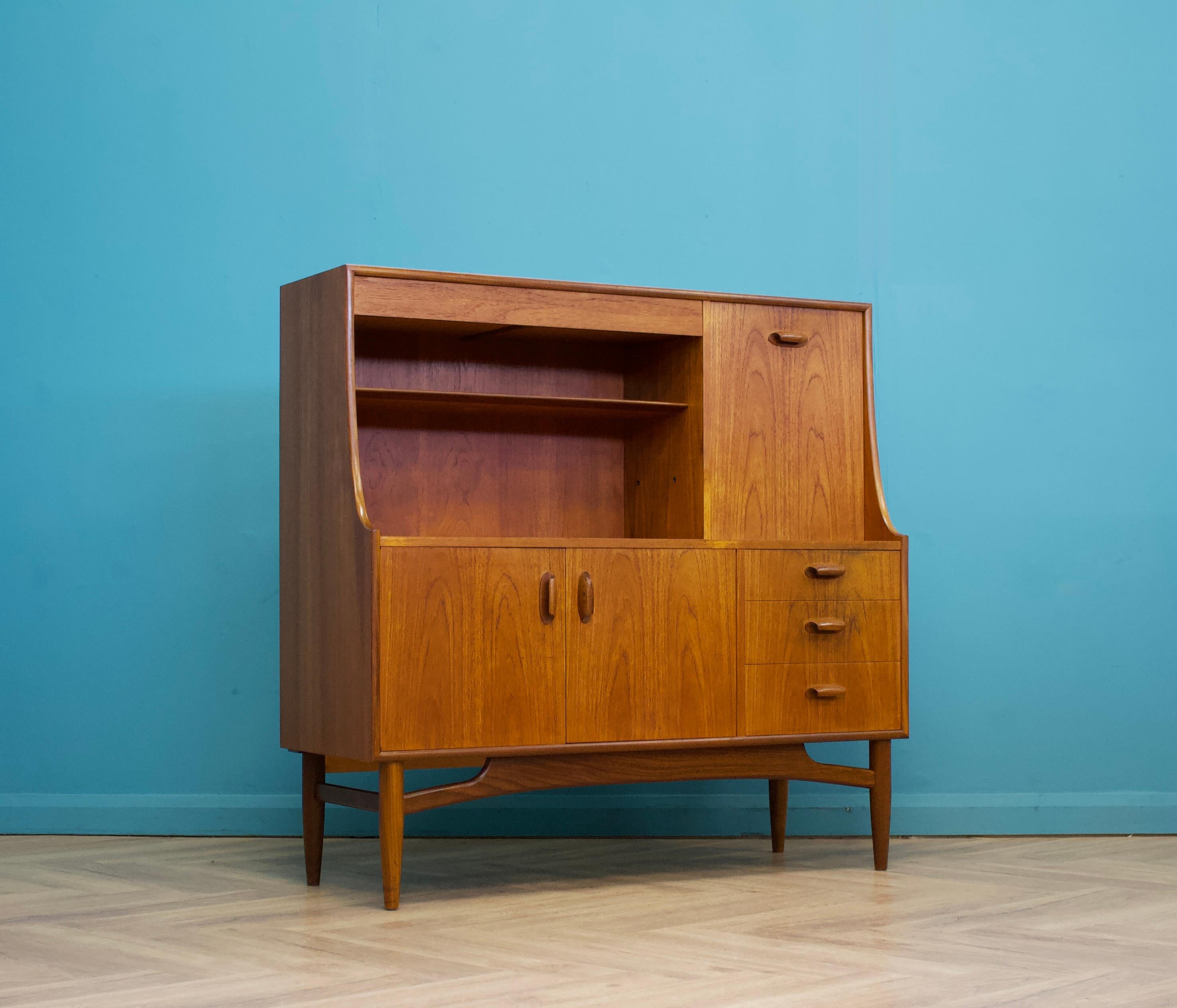 A highboard or drinks cabinet by G Plan for the Brasilia range  - Circa 1960s

Featuring a pull down drinks cabinets, a cupboard and four drawers - one is concealed at the top above the shelf.

Each handle is solid teak