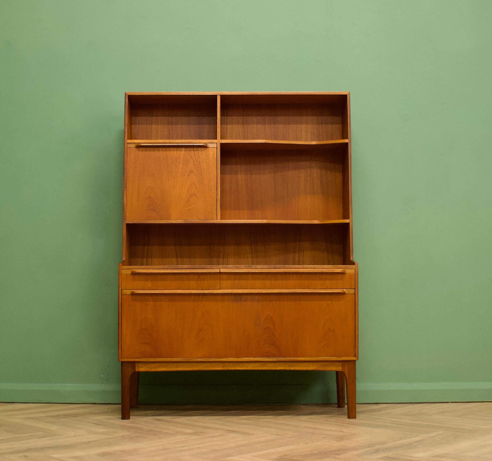 A teak drinks cabinet or highboard from McIntosh - Circa 1960s

It features two pull down drinks compartments, two drawers and shelves

The piece stands on slightly splayed legs and each handle is solid teak
