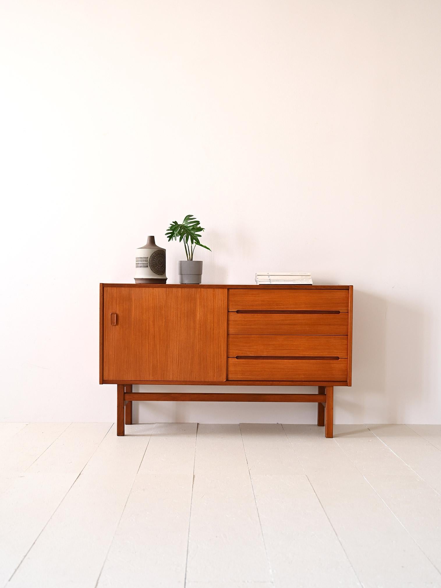 Scandinavian sideboard from the 1960s with drawers with a wood-carved handle.

This Swedish modern antique sideboard is an elegant piece of furniture with refined lines, consisting of a storage compartment with a sliding door on one side and two