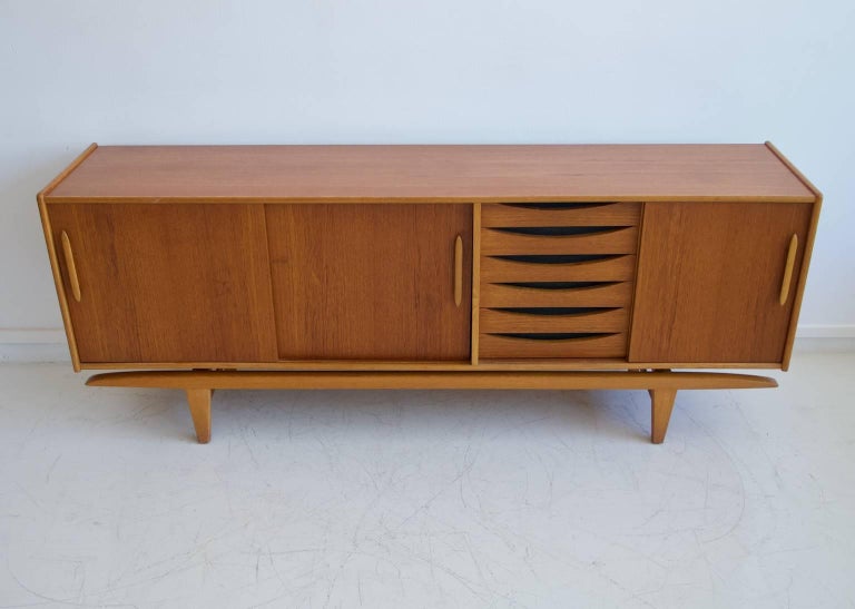 Teak sideboard manufactured in Sweden by Ajfa Tibro, circa 1970. Interior drawers made of oak. Front with sliding doors that reveal shelves on both sides and six drawers.