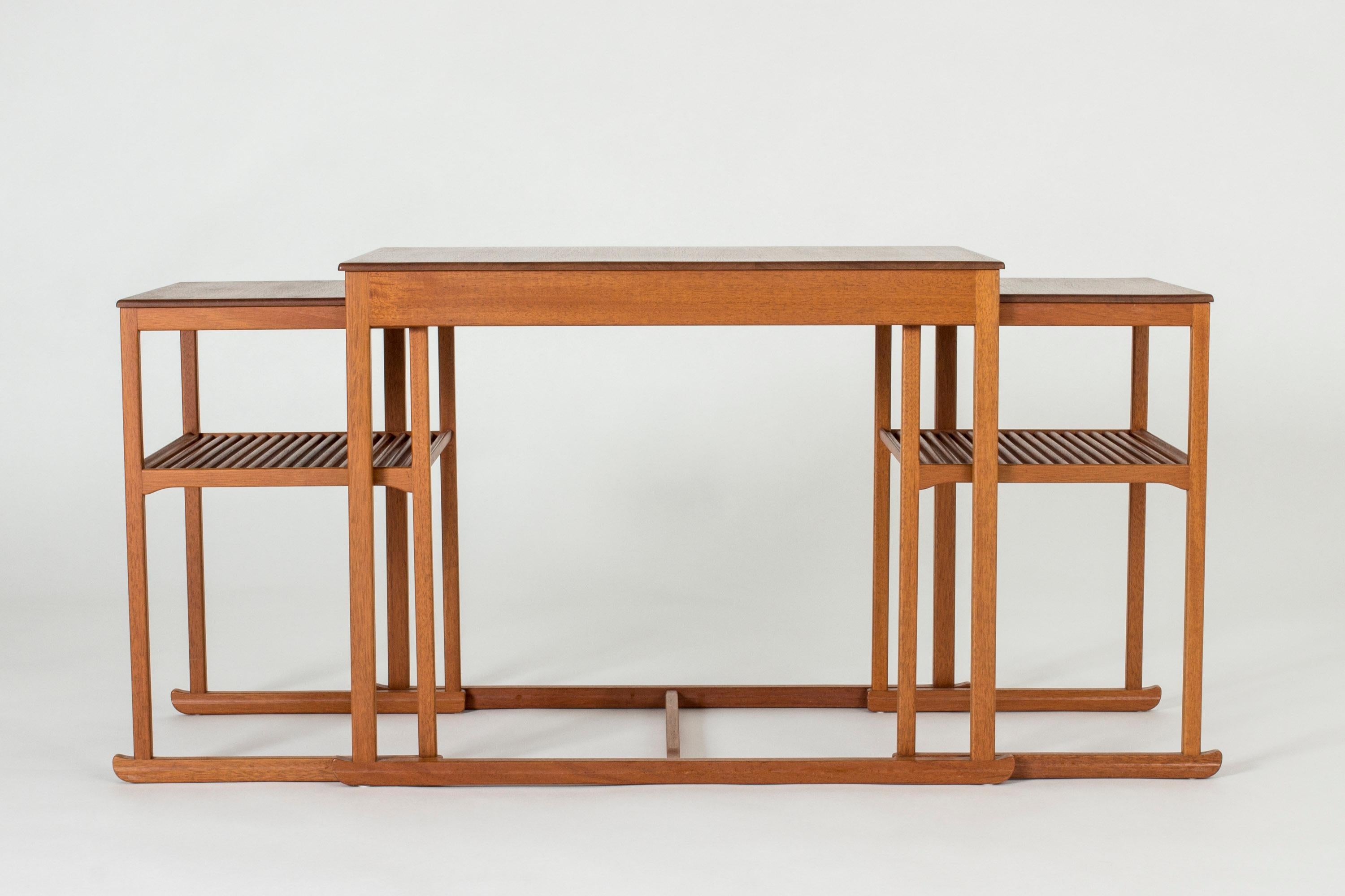 Beautiful “The Sled” nesting table by Carl Malmsten, made from teak. Light, graceful design with sled shaped legs and a discreet decor of inlaid spheres at the edges of the table tops.