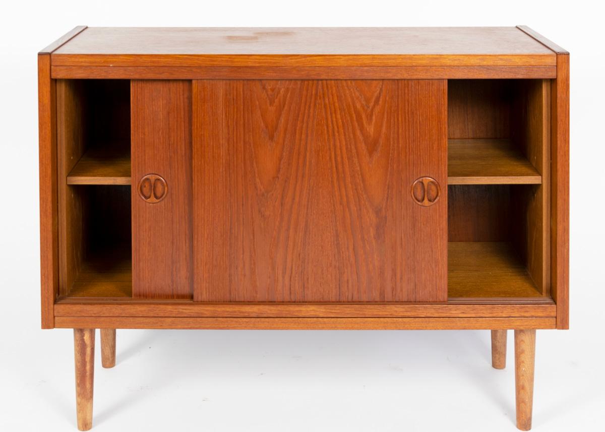 Smart little teak cabinet from the 1960s-1970s. Scandinavian design, Minimalistic form. Behind the sliding doors one shelve. Handels made of solid teak as well as the tapered legs.
Maintained in good condition, directly to use.
Made in Denmark in