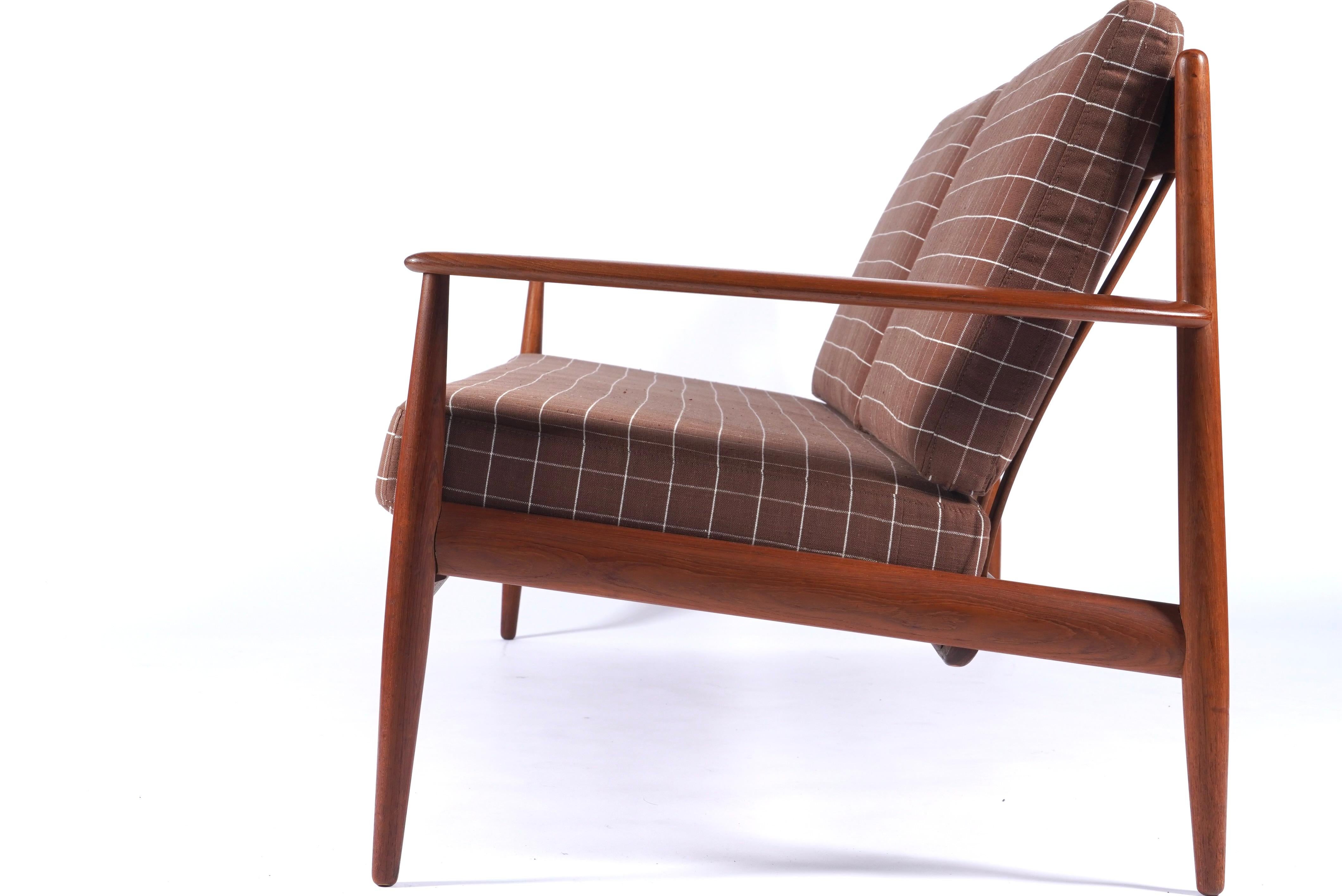 Three-seater sofa with solid teak frame by Grete Jalk. New cushions upholstered in a dead stock windowpane check brown and ivory linen. Excellent condition overall, frame retaining original finish with only minor scuffs consistent with age and use. 