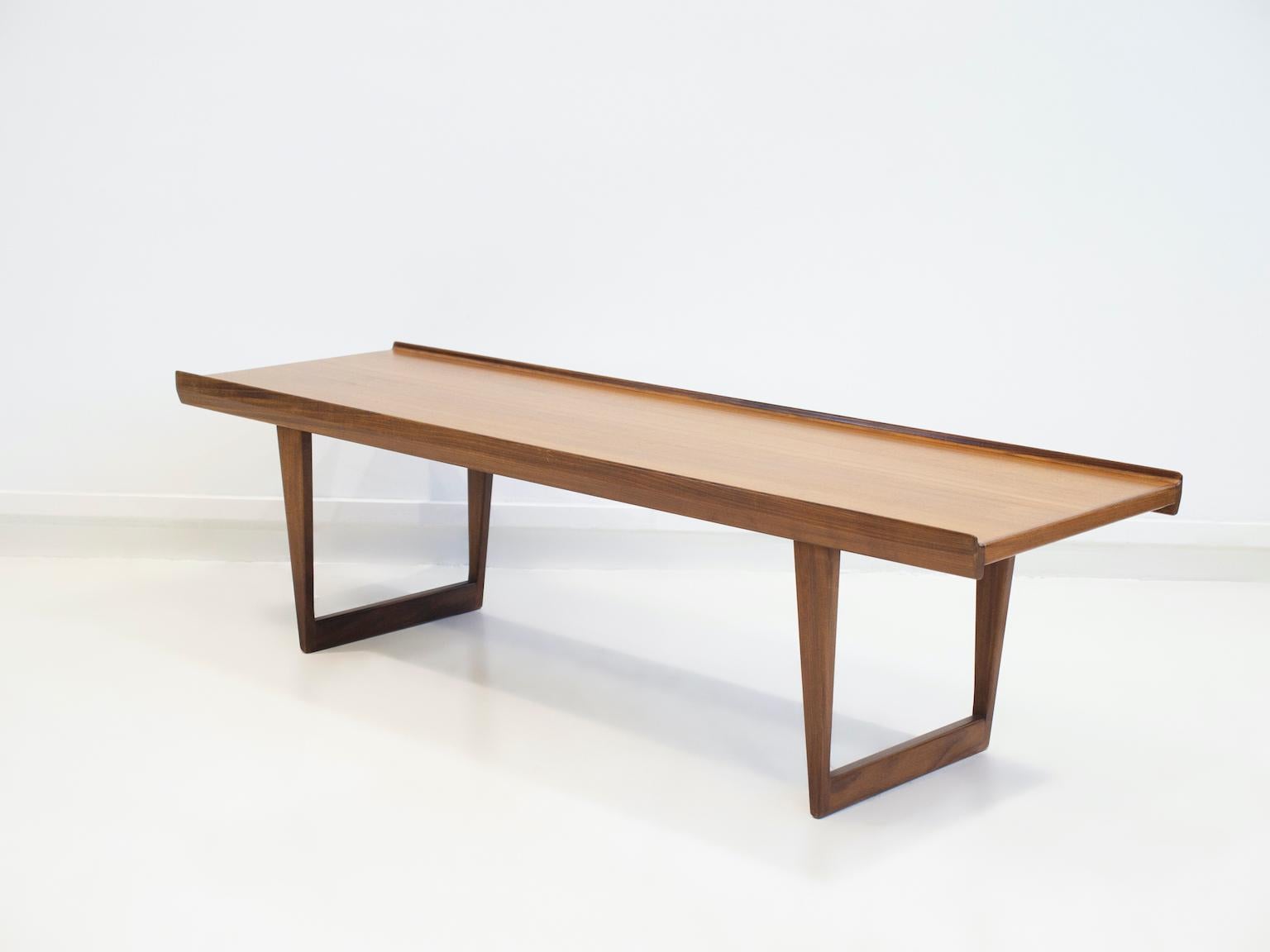 Coffee, side or sofa table of teak wood with higher edges mounted on v-shaped legs. Designed by Peter Løvig Nielsen and manufactured by Hedensted Møbelfabrik in the 1960s.