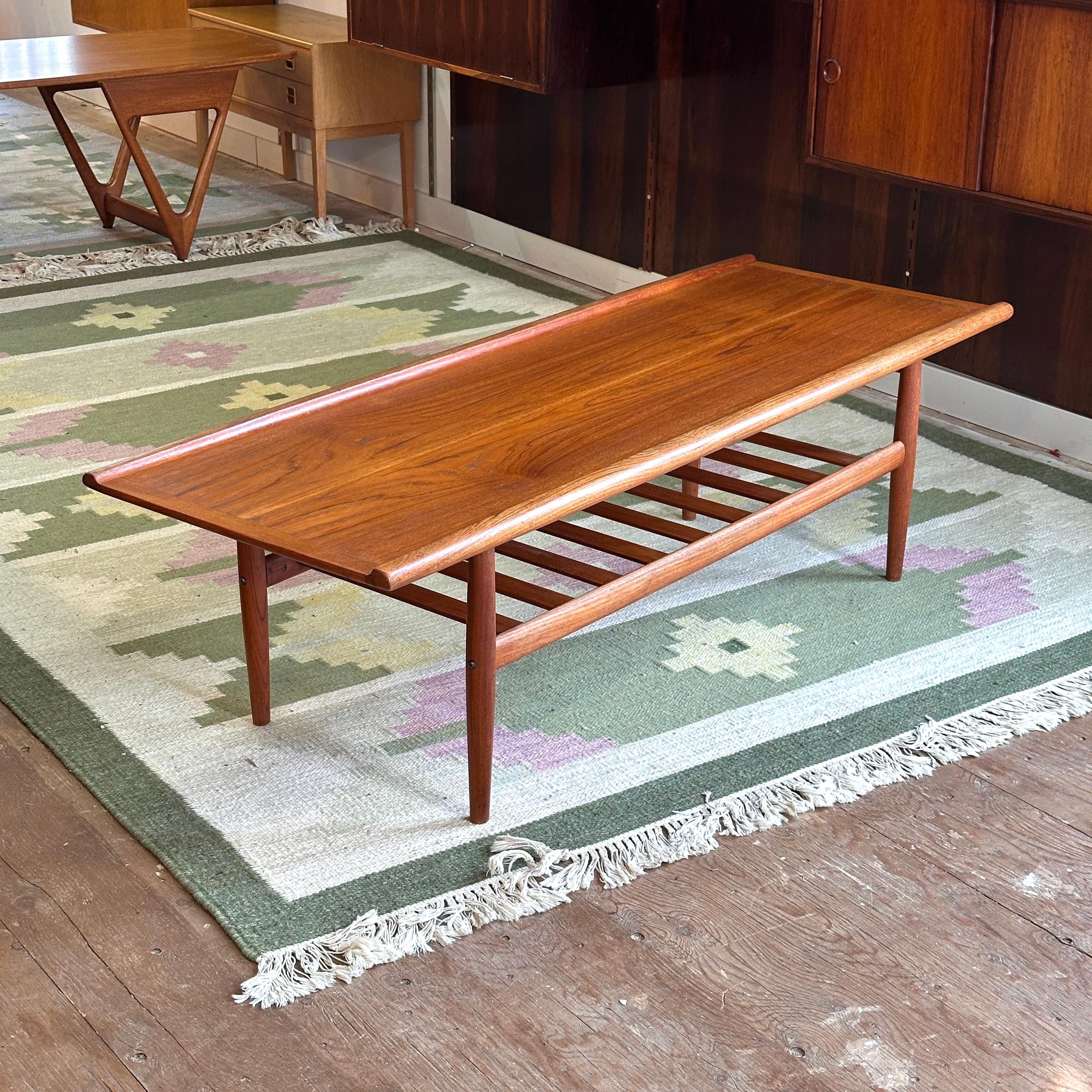 Condition: Excellent Vintage Condition - Refinished Surface

Dimensions: 59” L x 22” D x 17.25” H (10” H Lower Shelf)

Description: A vintage teak surfboard coffee table in the style of Grete Jalk.

Contact us for more details or pictures.