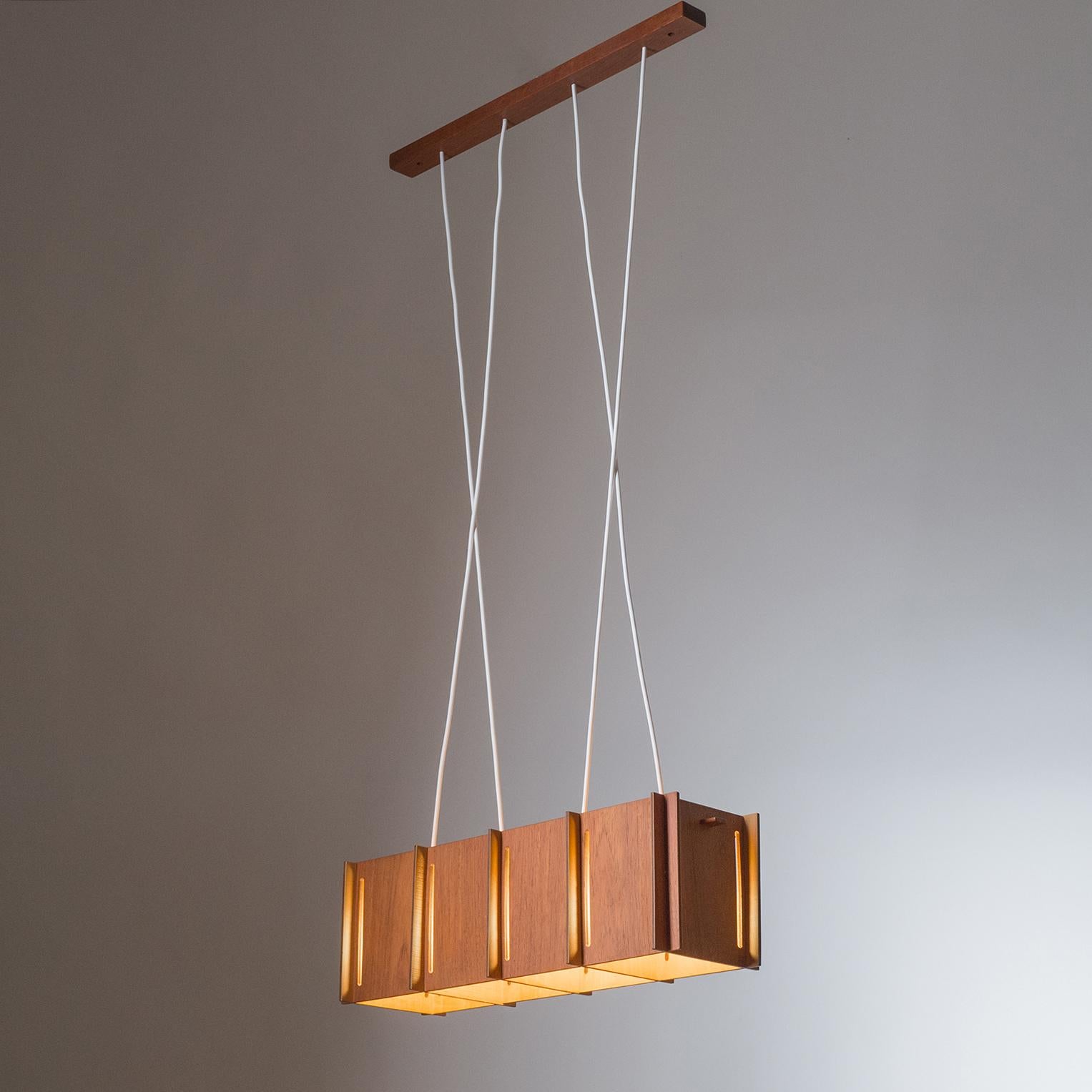 Rare Scandinavian Teak suspension chandelier from the 1950-1960s. Four original bakelite E27 sockets. Drop height adjustable up to a maximum of 45inches/115cm. Height of body is 6.7inches/17cm.