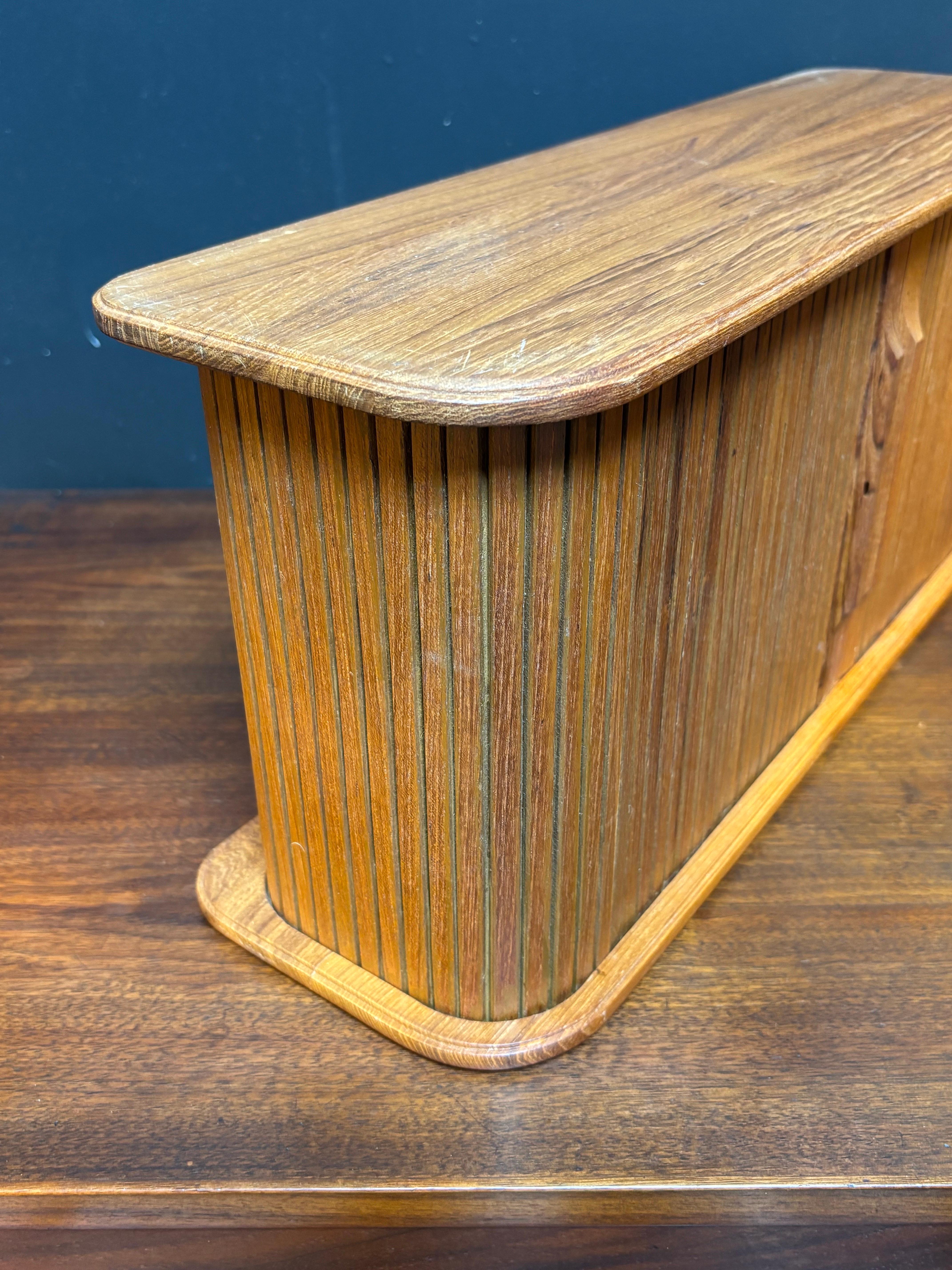 Teak Tambour Door Wall Storage Cabinet.  Easy mounting hooks to back makes it easy to install!  Marked Eppco Enterprises out of Cleveland Ohio but made in Thailand from the 70's.  One edge has been hit, shows damage as seen in photo!