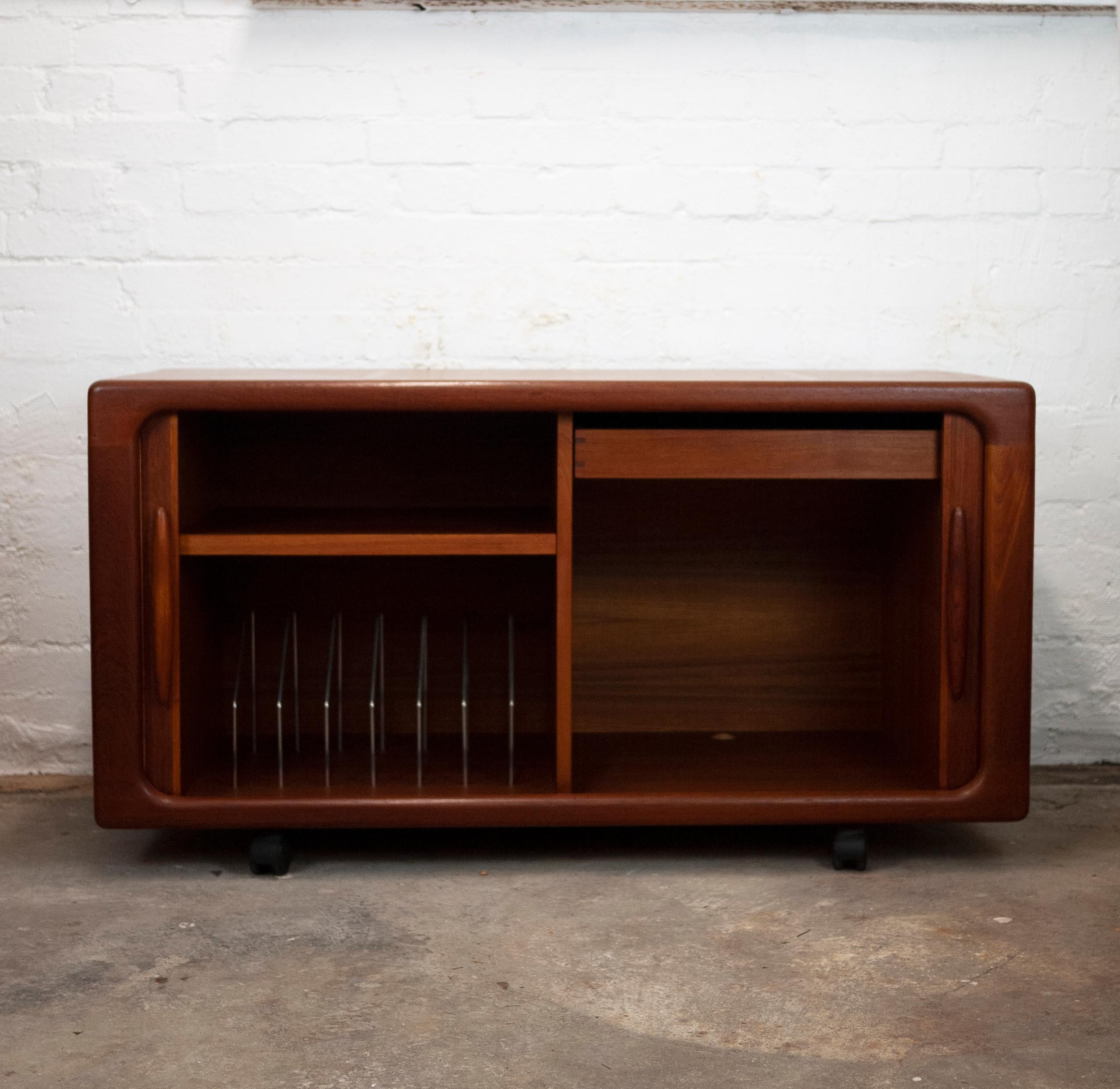 A vintage teak tambour door sideboard with inner drawer, shelf and record dividers. The sideboard sits on wheels.
Manufacturer - Dyrlund
Design Period - 1960 to 1969
Country of Manufacture - Denmark
Style - Mid-Century
Detailed Condition - Good