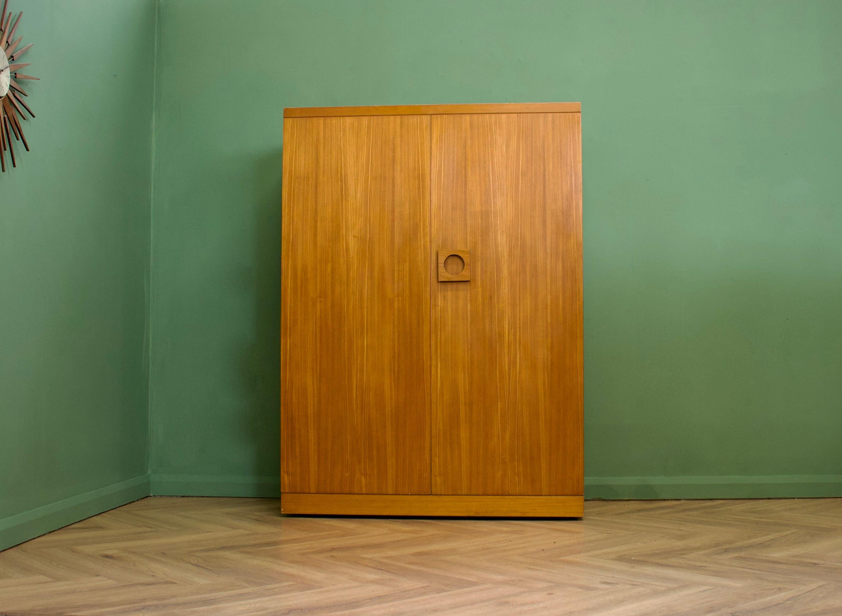 A freestanding teak wardrobe from Uniflex - standing on concealed castors
Featuring a rail the full width and oversized solid teak handles
There's another matching smaller wardrobe available on a separate listing


This wardrobe dissembles.