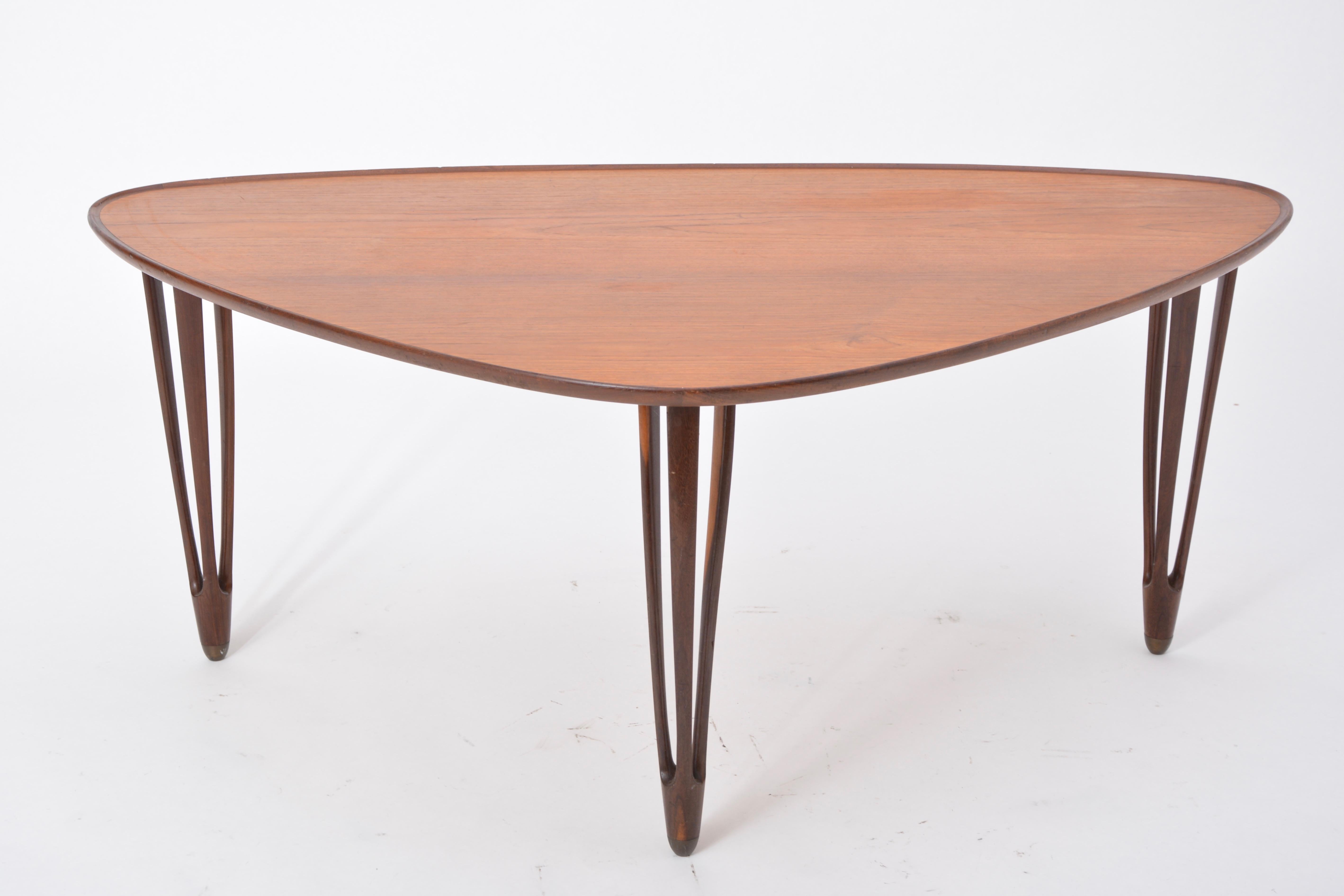 Danish Mid-Century Modern Teak tripod coffee table from BC Mobler

An asymmetrical tripod coffee table made from teak with rounded edges and brass feet, produced by Danish company B.C. Møbler in the 1950s.