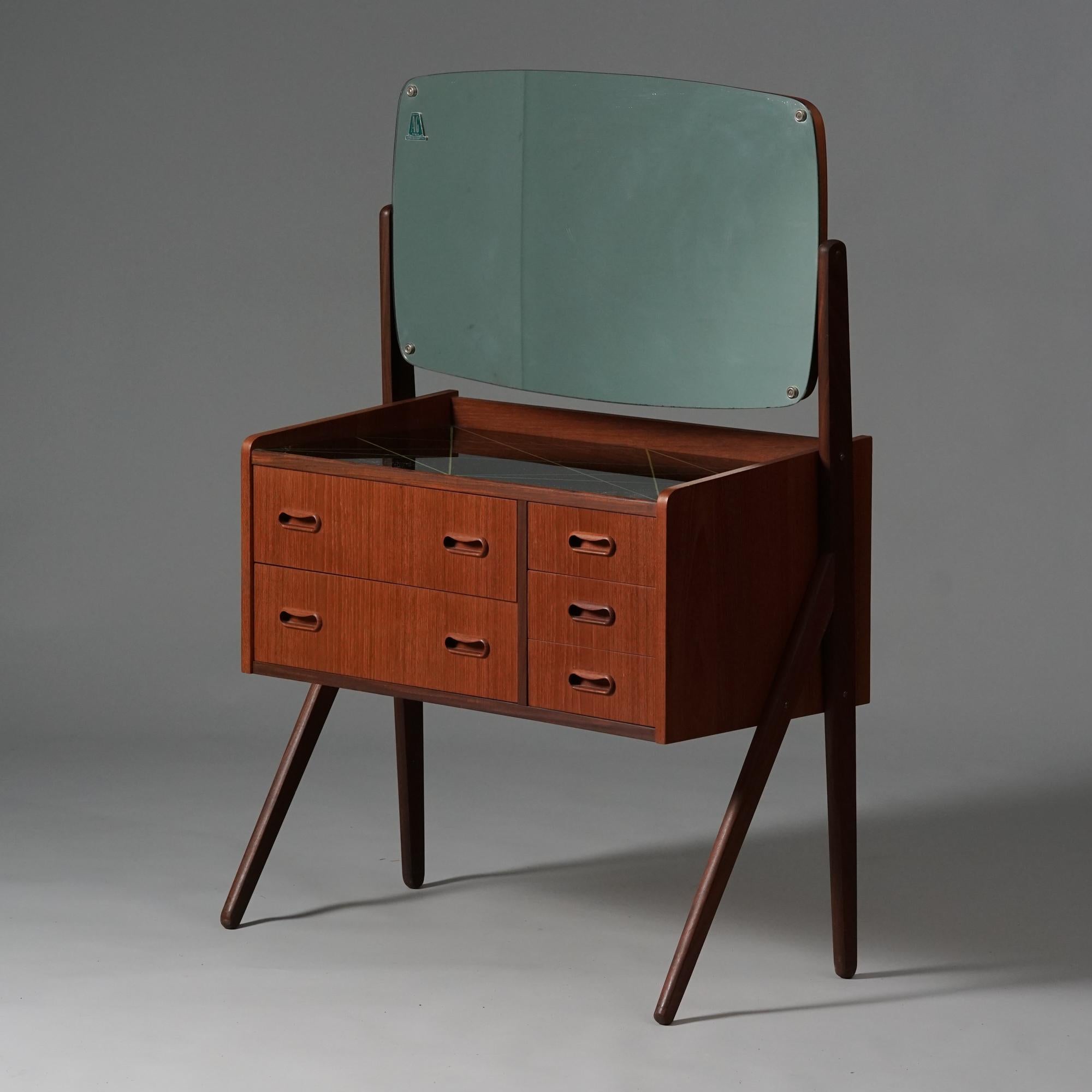 Teak vanity, manufactured by AG Spejl Kobberbeskyttet in Denmark, 1960s. Teak frame, glass table top. Mirror direction is adjustable. Marked. Good vintage condition, patina consistent with age and use. 

Measurements: width 78.5 cm, depth 39 cm,