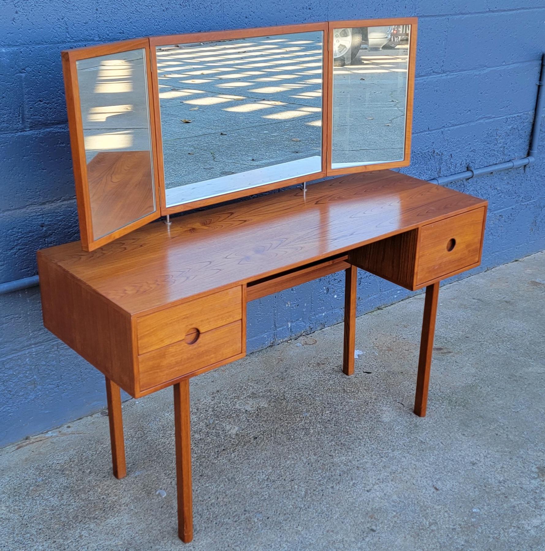 Teak Danish Modern vanity or dressing table designed by Kai Kristiansen for Aksel Kjersgaard, Denmark. Adjustable height and cant to folding mirror. Exceptional beauty to patina and teak wood grain. Knee hole sitting area with 3 drawers for storage.