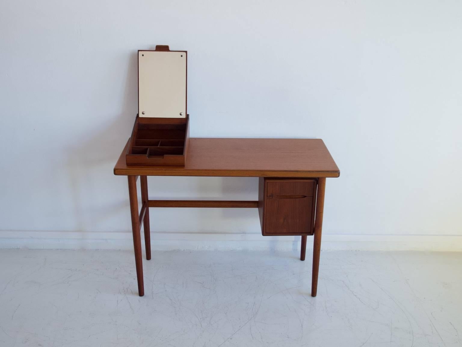 Danish dressing table from circa 1950-1960. Design attributed to Kurt Ostervig. Veneered with teak. The vanity features a compartment with a mirror on top of the table and drawers underneath. Restored, great condition. Measurements: The total height