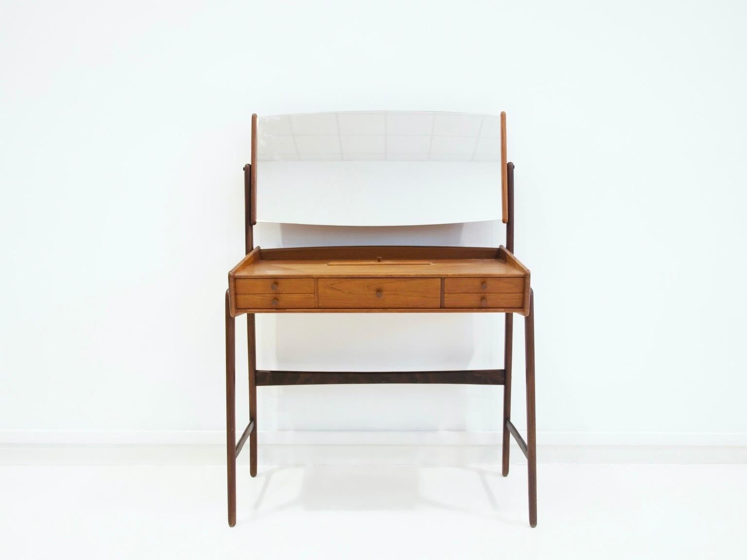 Teak dressing table with adjustable mirror by Svend Åge Madsen. The vanity has five drawers to store things. Table's height 71 cm, height including mirror 113 cm.