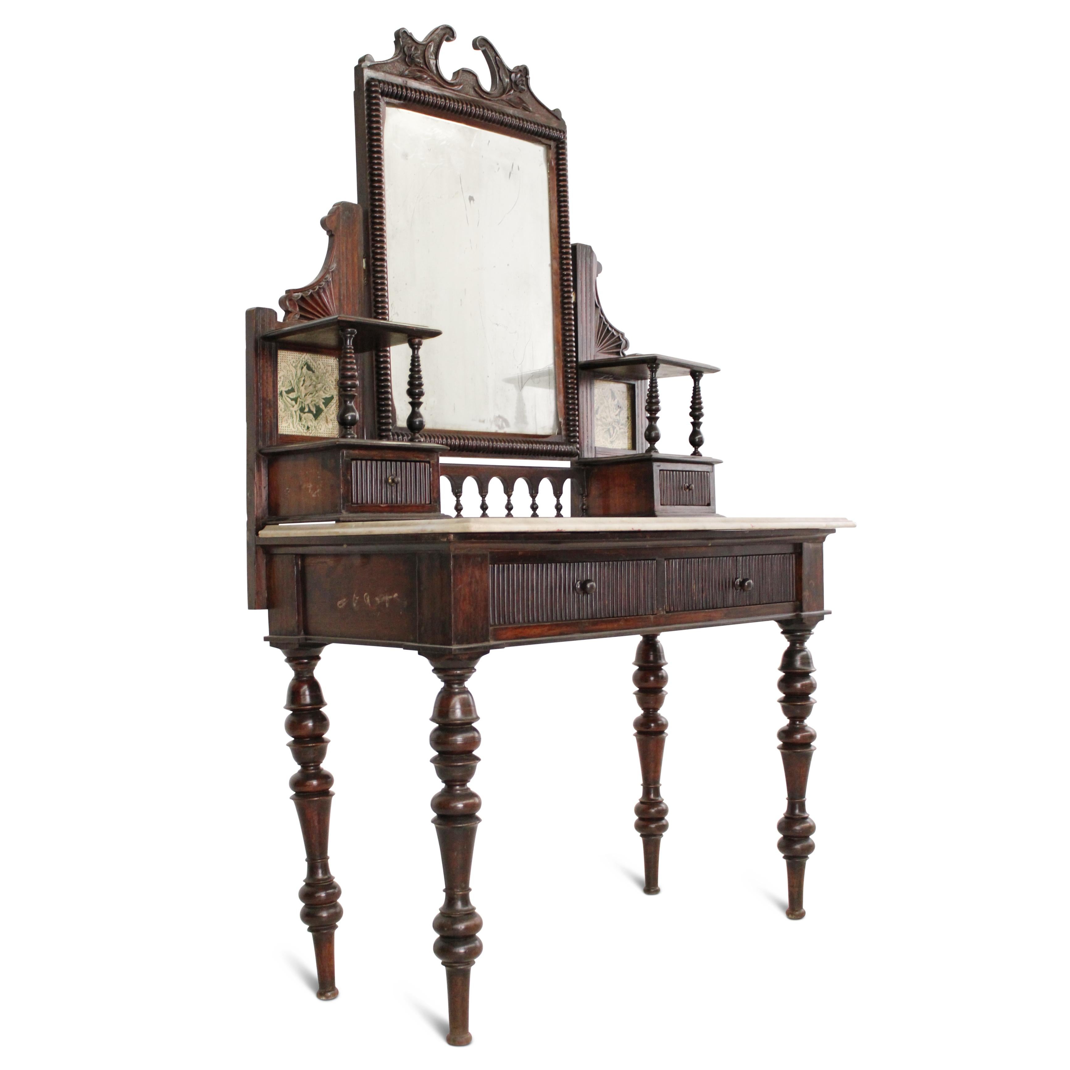 An exquisite Victorian teak and marble top dressing table, retaining its original mirror and intricate carved detail. This exceptional piece, with its original polish and charming patina, embodies enduring grace. The finely turned feet at the base