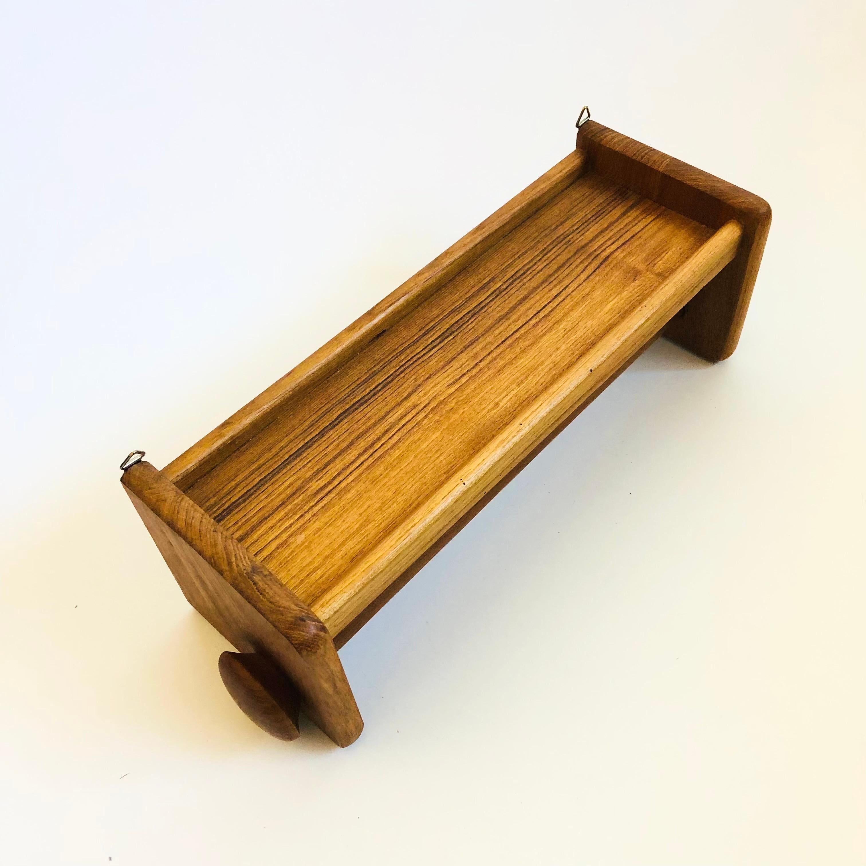 Un porta asciugamani di carta in teak vintage con una mensola sopra. Un bel design minimalista e multifunzionale. I lati si svitano per rimuovere l'asta e conservare gli asciugamani di carta. 2 ganci sul retro per il montaggio a parete. Prodotto in