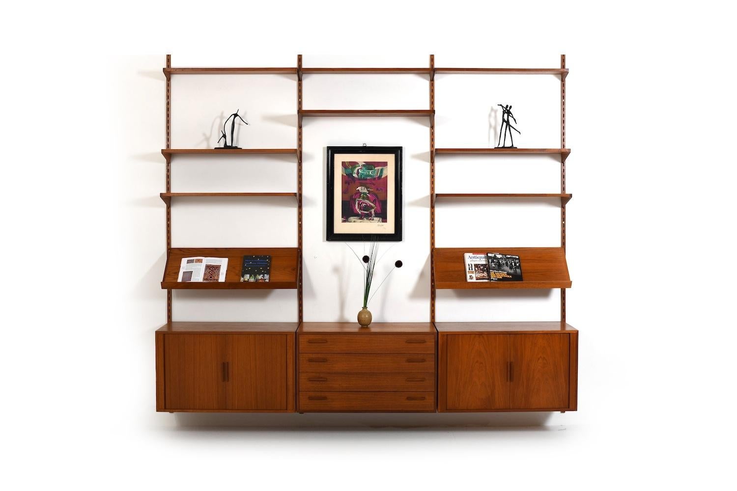Parete attrezzata Kai Kristiansen in teak. Prodotto da FM Feldballes Møbelfabrik Danimarca negli anni '60. 
Il mobile a parete è composto da:
- 8 ripiani
- 2 ripiani per riviste
- 3 armadietti
- 4 staffe da parete

misure dettagliate:
ripiani: 2x 