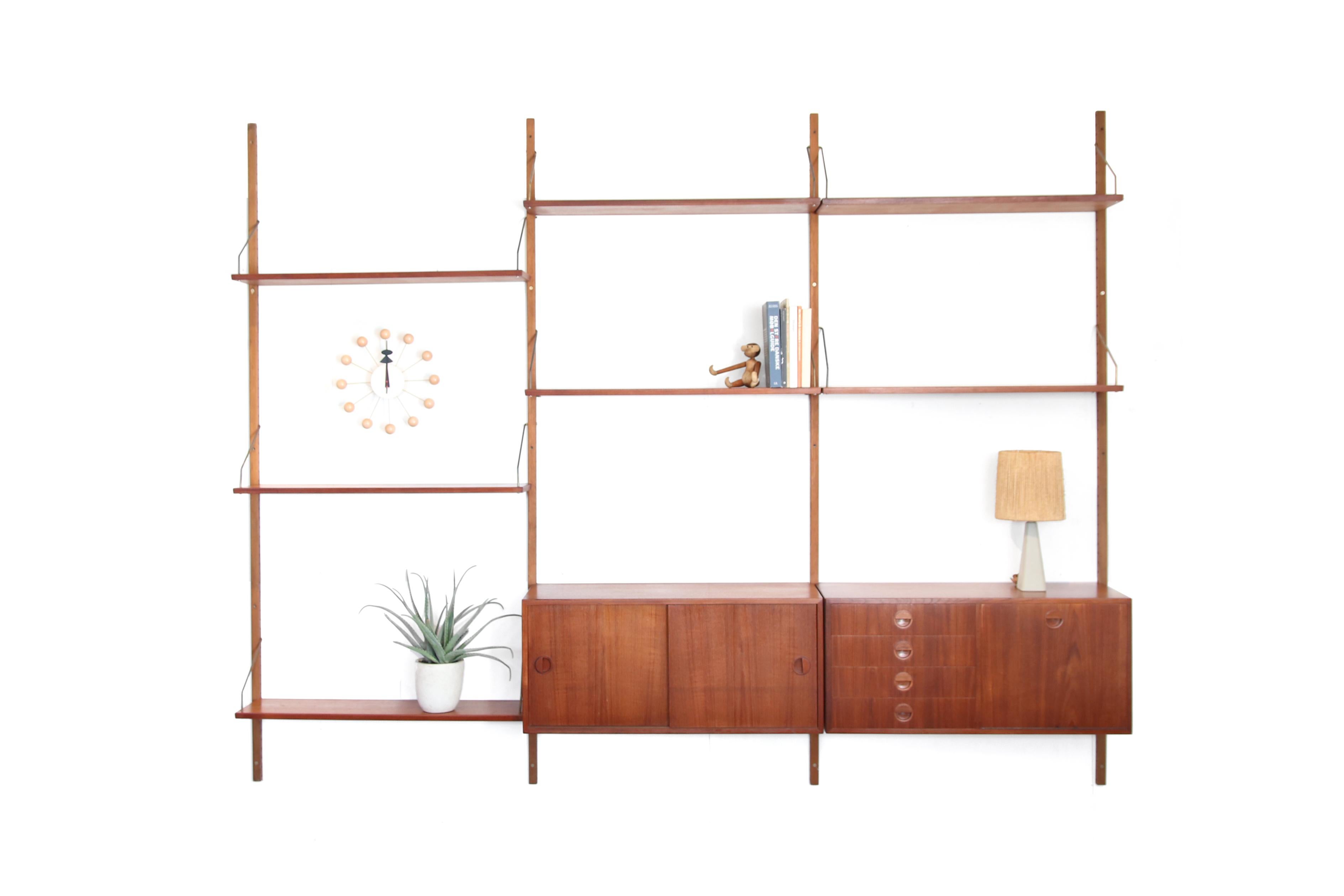 Beautiful vintage modular Danish wall cabinet designed by Rud Thygesen & Johnny Sorensen for HG Møbler. The cabinet has 4 wooden uprights, 7 shelves, a cabinet with sliding doors and a cabinet with 4 drawers and a flap. The wall system is made of