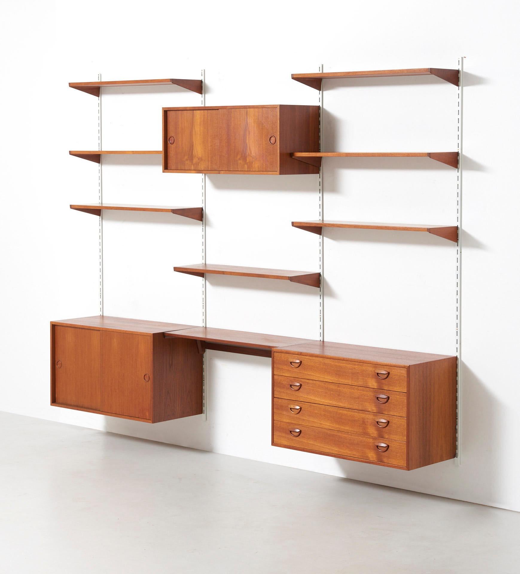 A wall unit in teak consisting of a chest of drawers, 2 cabinets and 7 shelves. Design by Kai Kristiansen in circa 1960. Made by FM (Feldballes Møbelfabrik) in Denmark.
