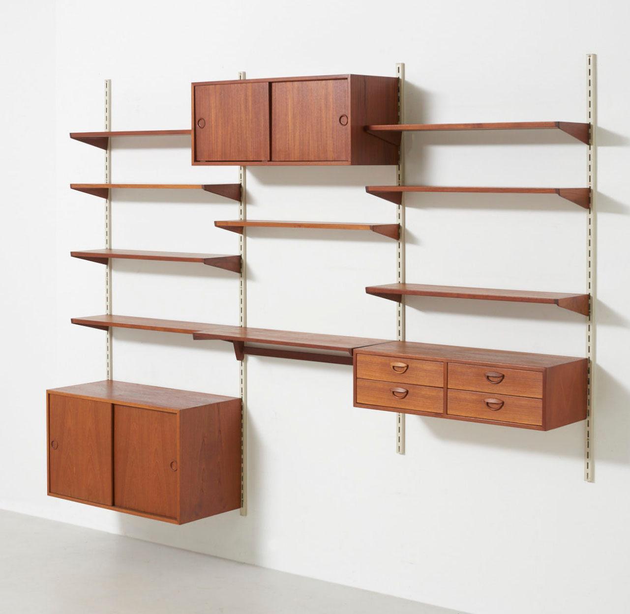 A wall unit in teak consisting of a chest of drawers, 2 cabinets and 9 shelves. Design by Kai Kristiansen in circa 1960. Made by FM (Feldballes Møbelfabrik) in Denmark.
 