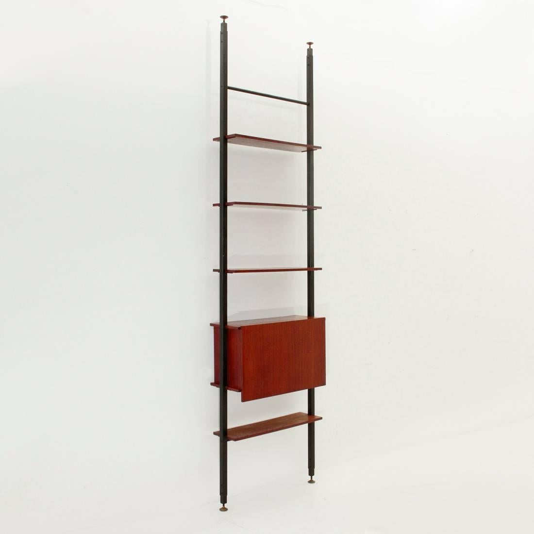 Wall unit produced by Domus Linea based on a project by Marco Lavarello.
Telescopic uprights in black painted metal. Brass feet.
Shelves and storage compartment in teak veneered wood.
Good general conditions, some signs due to normal use over