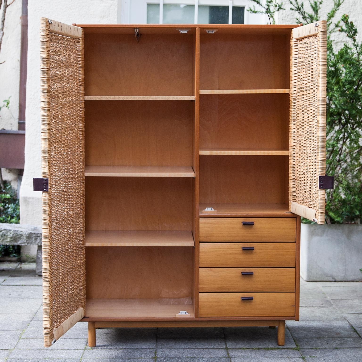 Sebastian Muggenthaler wardrobe with four drawers from 1960s. Wooden construction, teak veneer, teakwood, meshwork, leather.

 