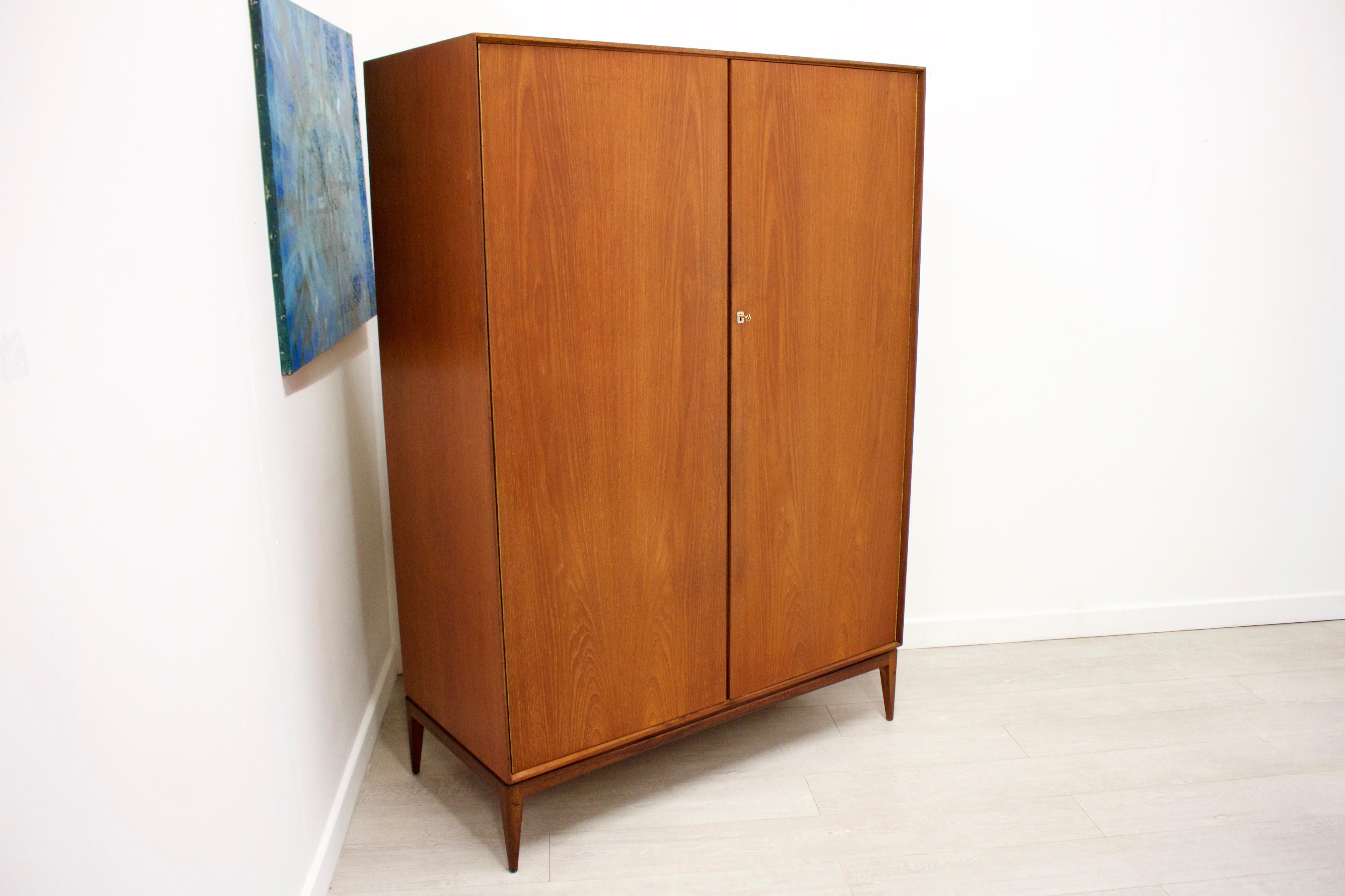- Mid-Century Modern wardrobe
- Manufactured by McIntosh
- Made from teak and teak veneer
- Featuring 2 hanging rails, a shelf in the top right, and a mirror on the inside of
the right door.