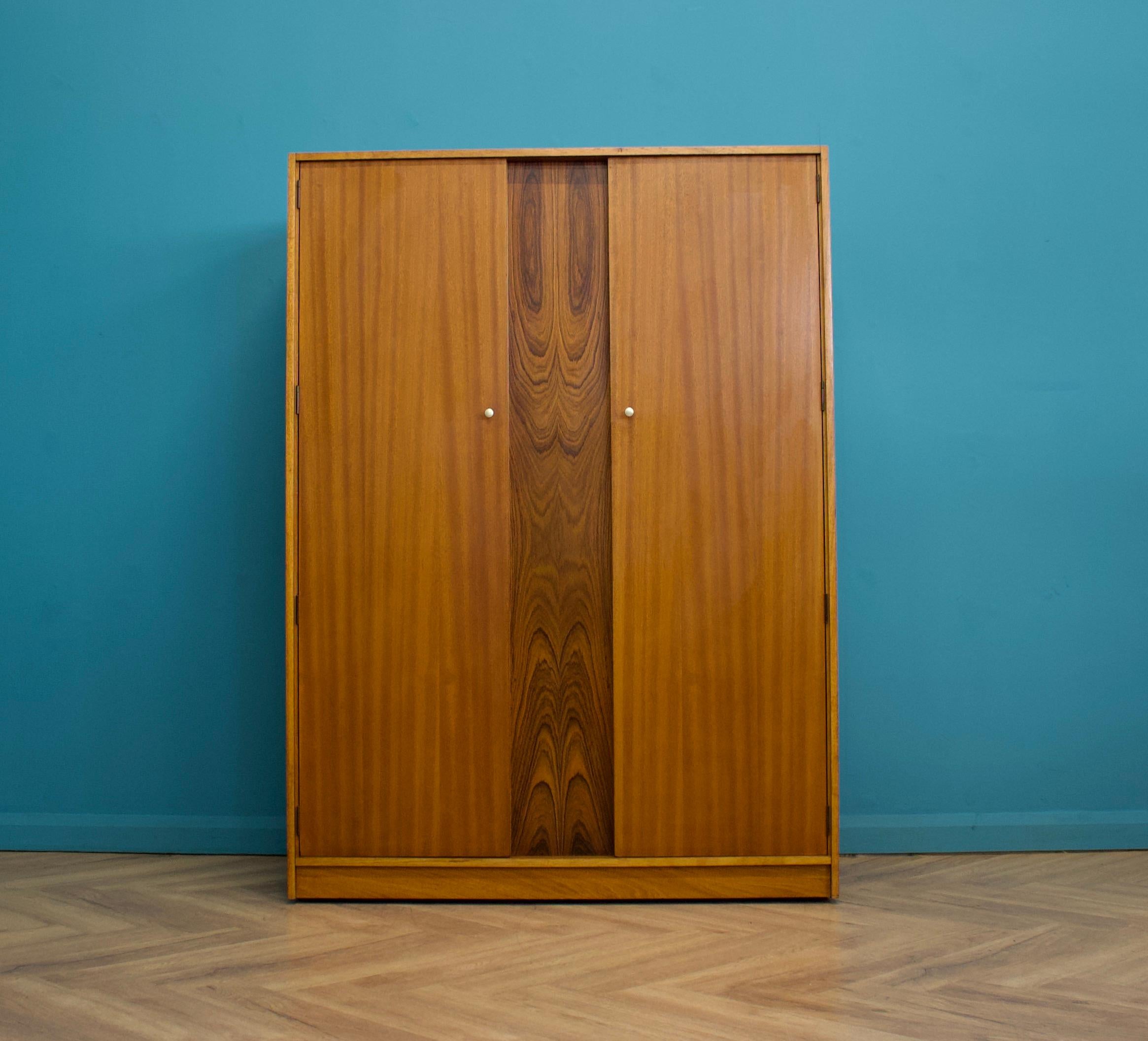 Ein freistehender zweitüriger Teakholz-Kleiderschrank von Uniflex
Hergestellt in den 1960er Jahren


Ausgestattet mit zwei Kleiderstangen und einem Regal, Schubladen
Der Stil dieses Schranks ist recht minimalistisch - mit seinen klaren Linien - die