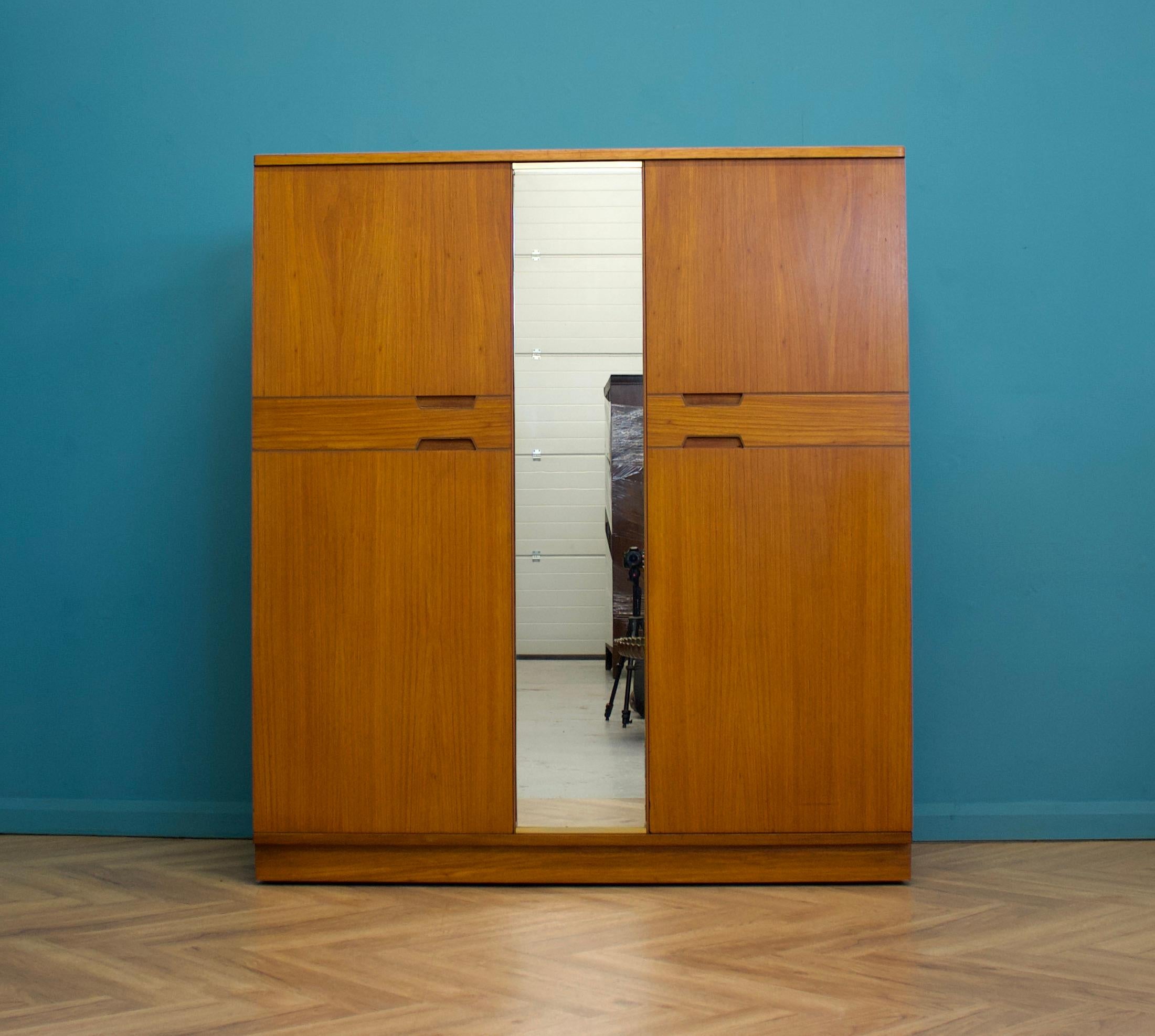 A freestanding double door teak wardrobe from Uniflex - designed by Gunther Hoffstead
Made during the 1960s

Fitted out with two clothes rails and shelves
The style of this wardrobe is quite minimalist - with it's clean lines
There's a full mirror