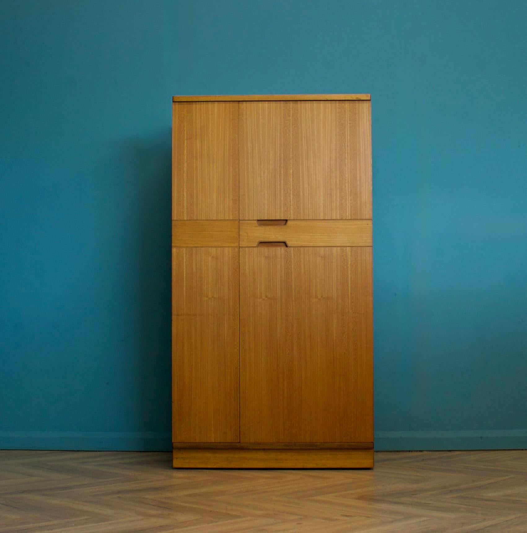 Un armadio freestanding a due ante in teak di Uniflex, progettato da Gunther Hoffstead.
Realizzato negli anni '60

Dotata di appendiabiti, cassetti e scaffali
Lo stile di questo guardaroba è piuttosto minimalista, con le sue linee pulite.

Questo